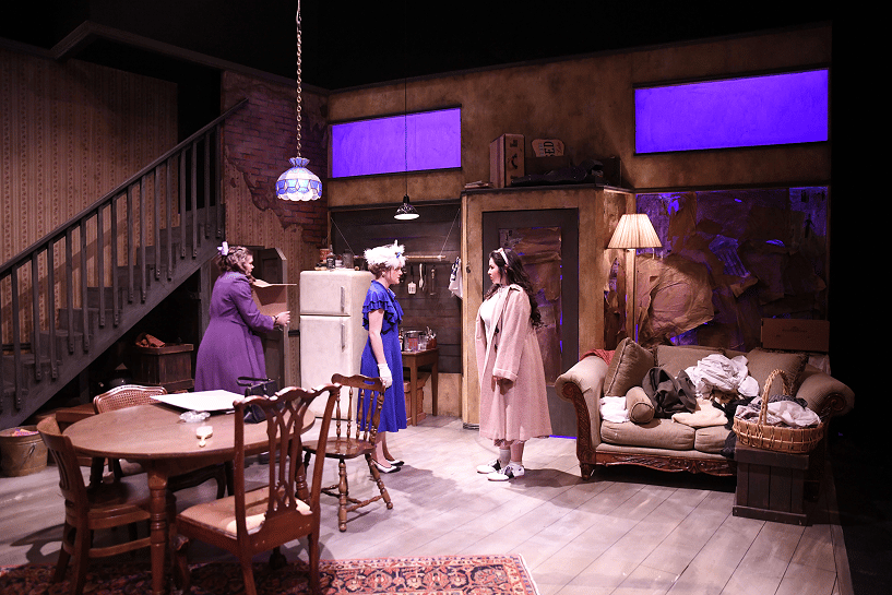 a group of women in a room with furniture and a table