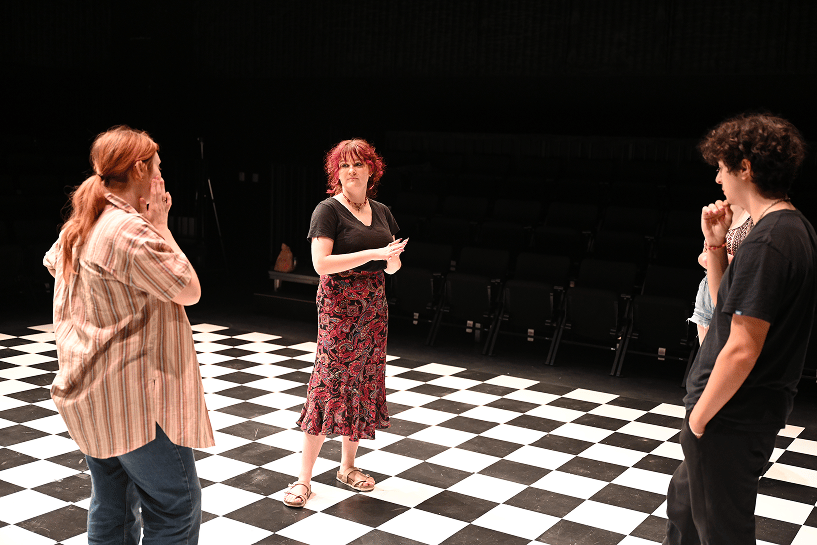 a person standing on a checkered floor with other people in the background