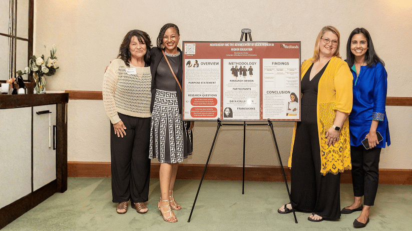 a group of women standing next to a sign