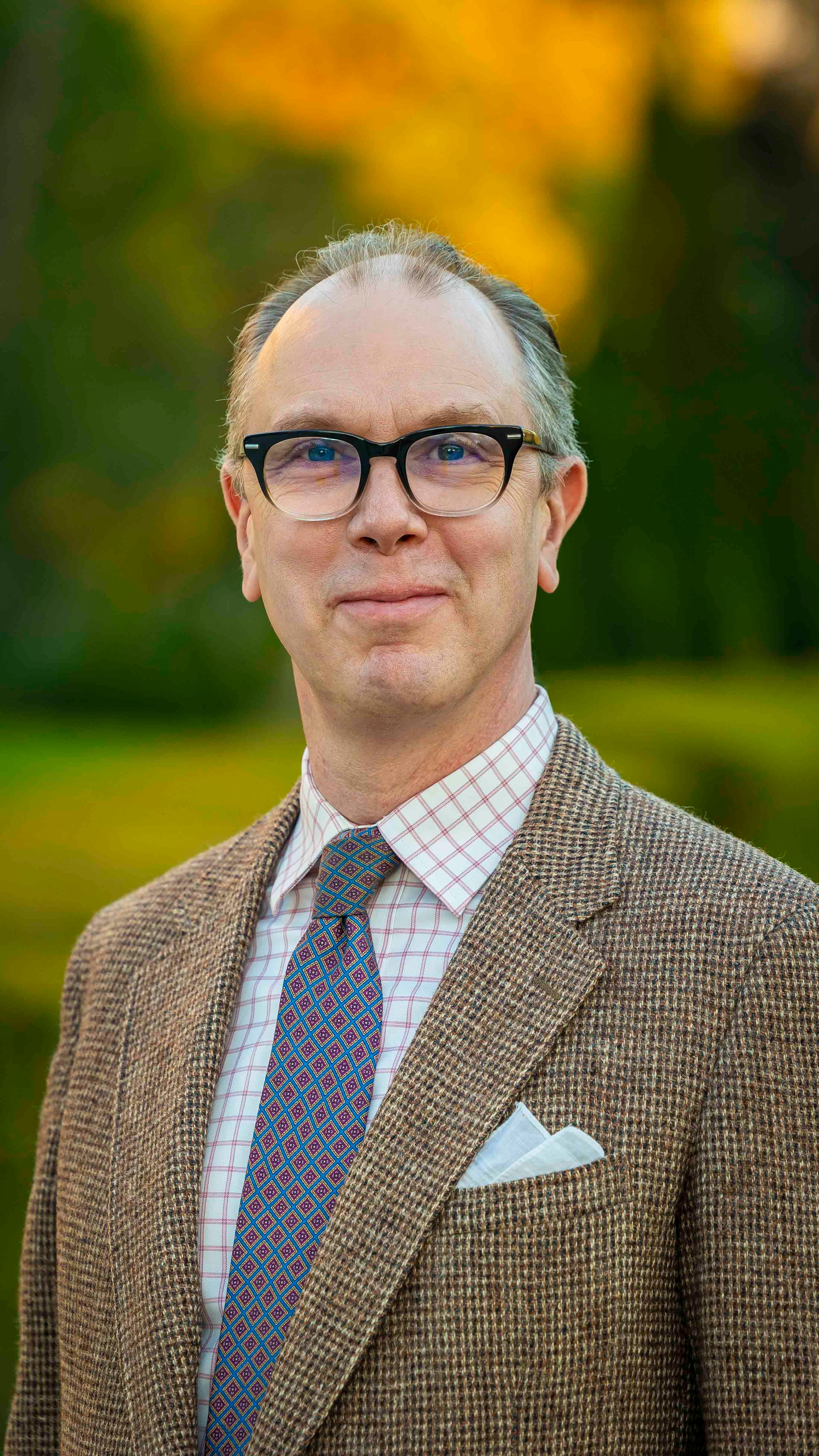 a man wearing glasses and a suit