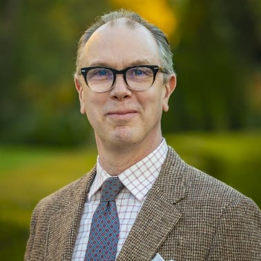 a man wearing glasses and a suit
