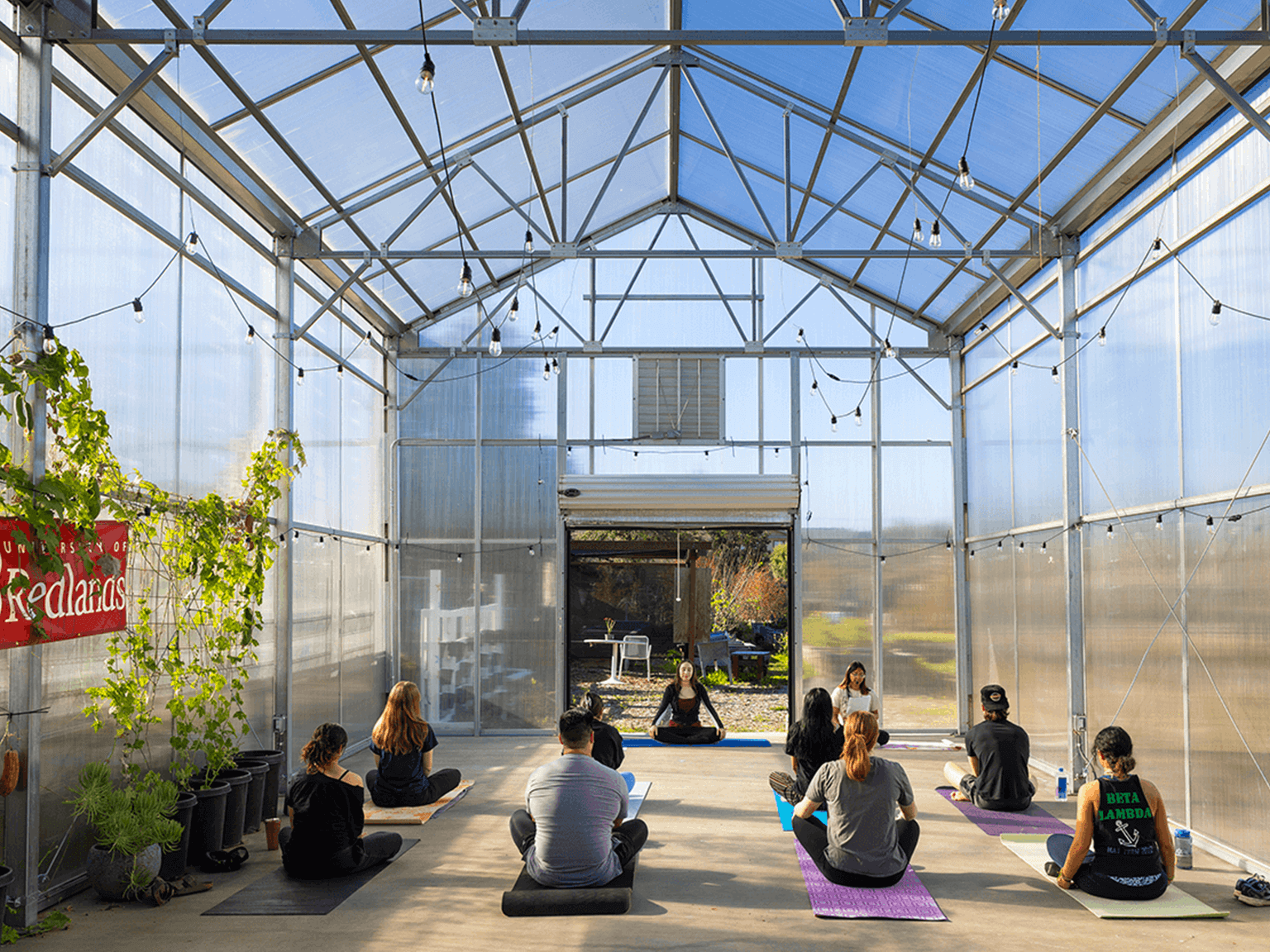 a group of people sitting in a room with a glass roof