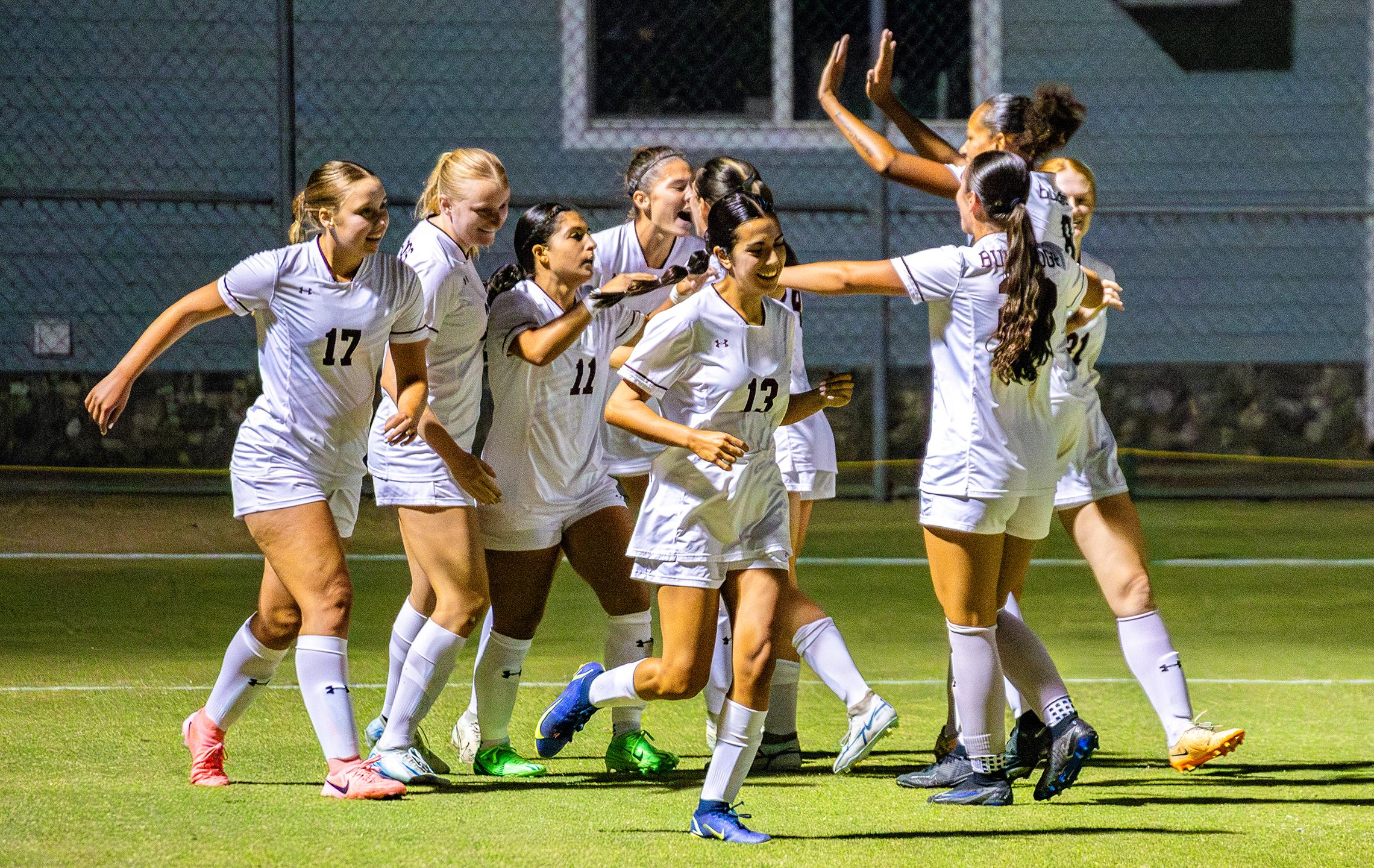 a group of women in white uniforms celebrating