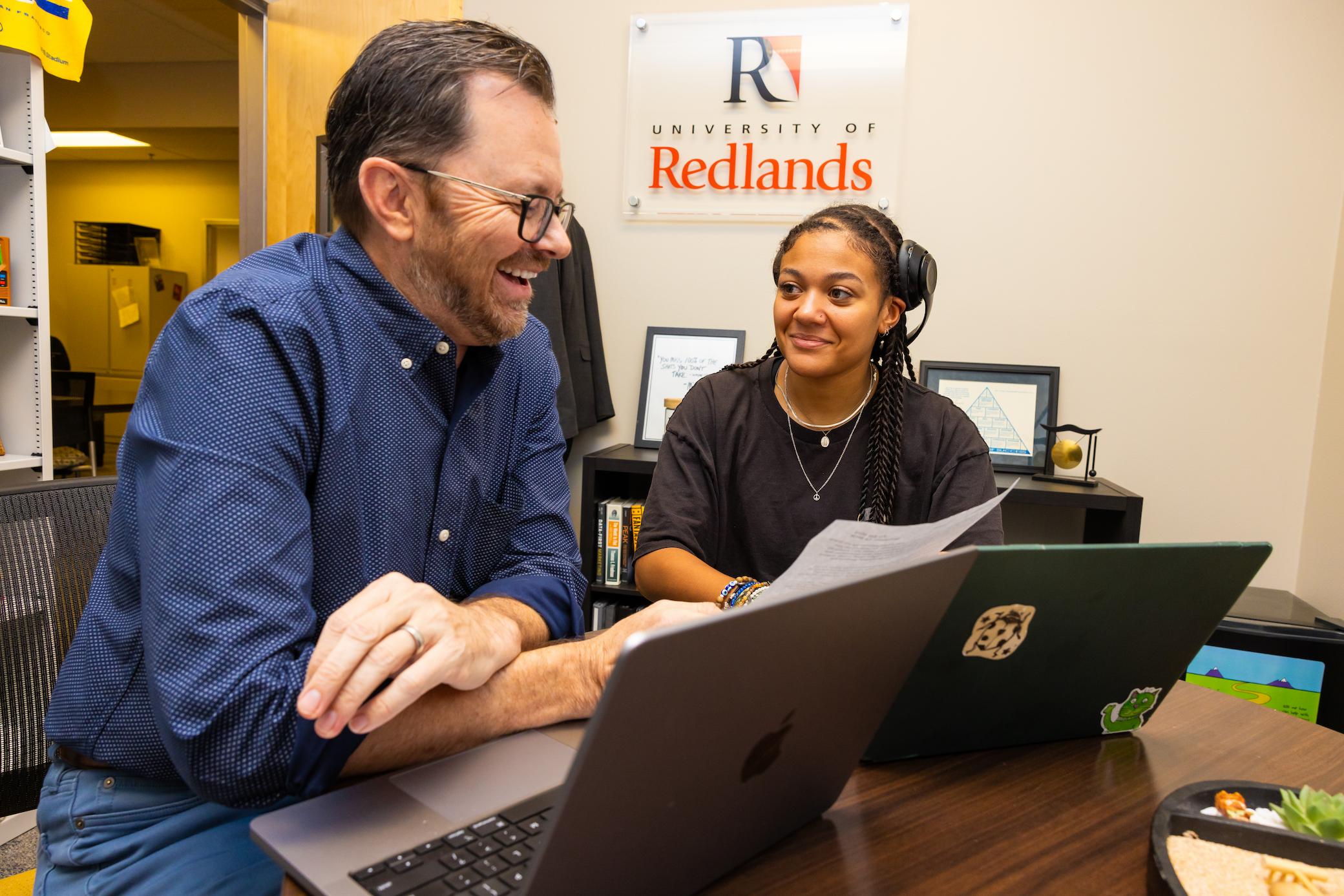 a man and woman looking at a laptop