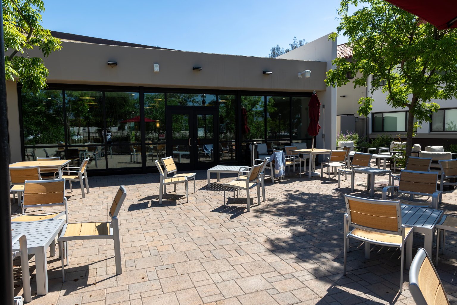 a patio with chairs and tables outside of a building