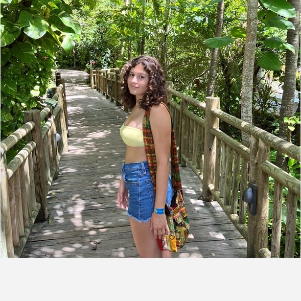 a woman standing on a wooden bridge