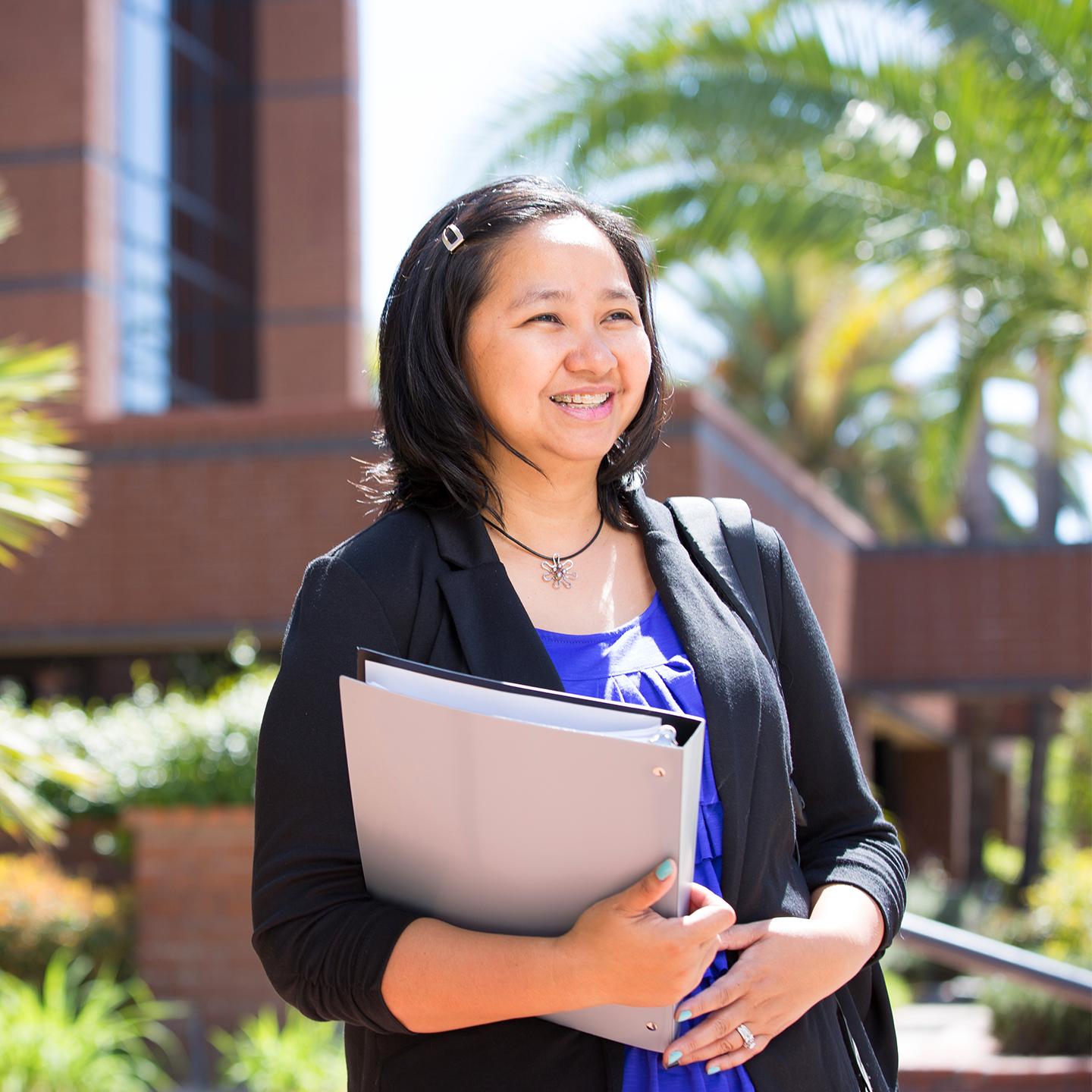 a woman holding a folder and smiling