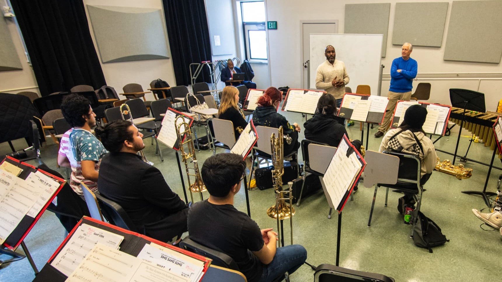 a group of people sitting in chairs in a classroom