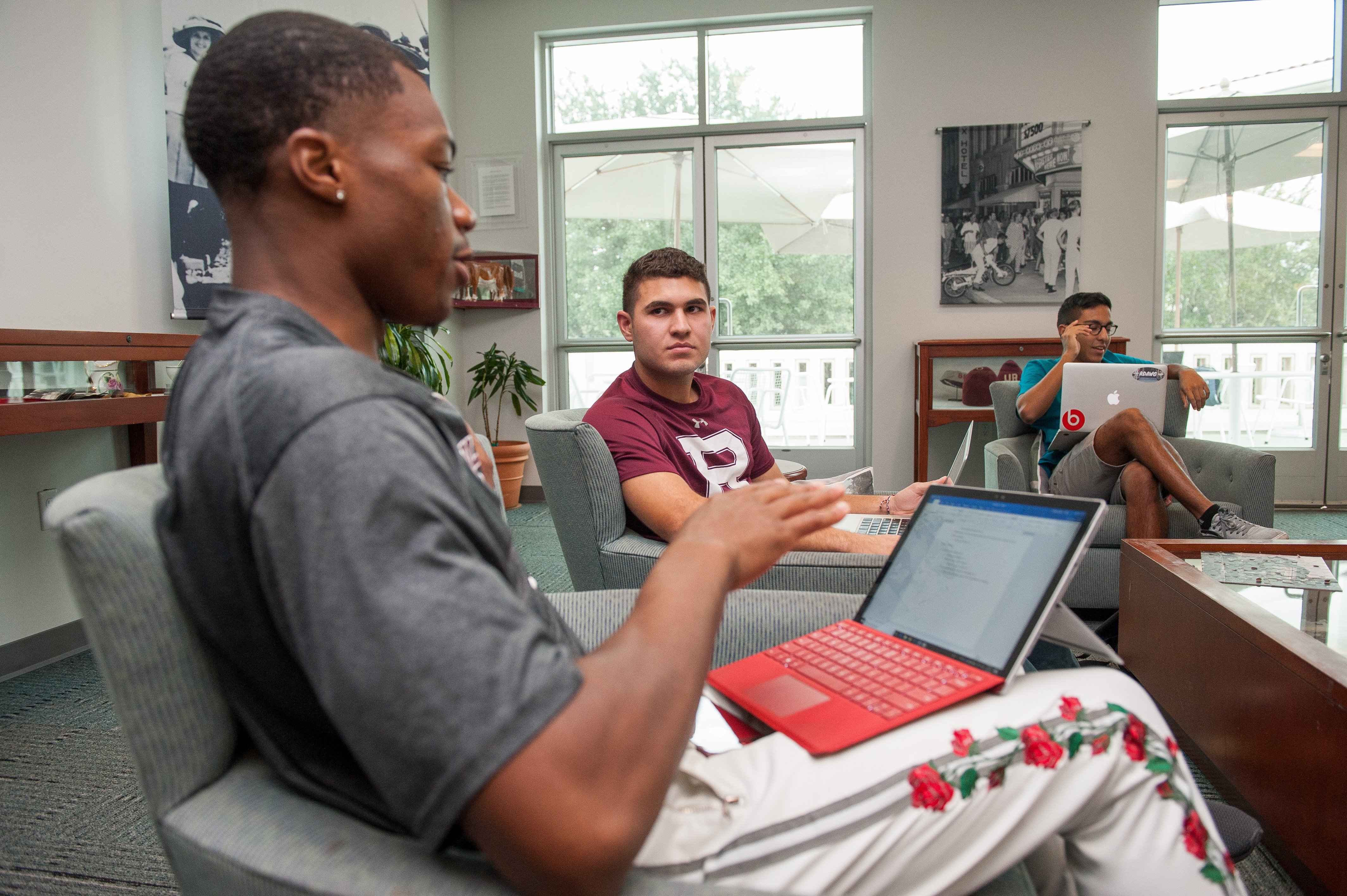 a group of men sitting in chairs with laptops
