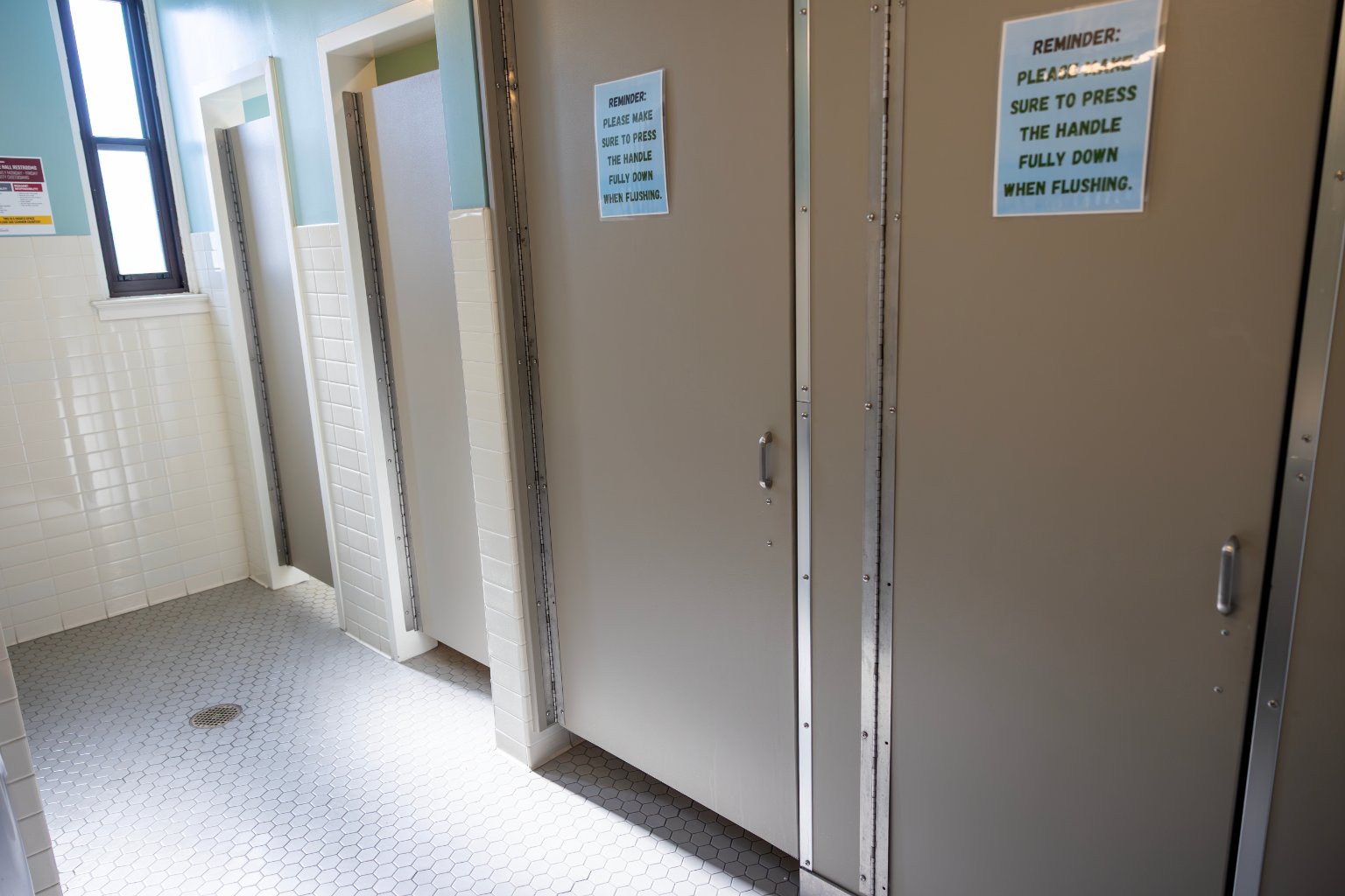 a bathroom with doors and signs
