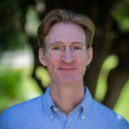 a man wearing glasses and a blue shirt