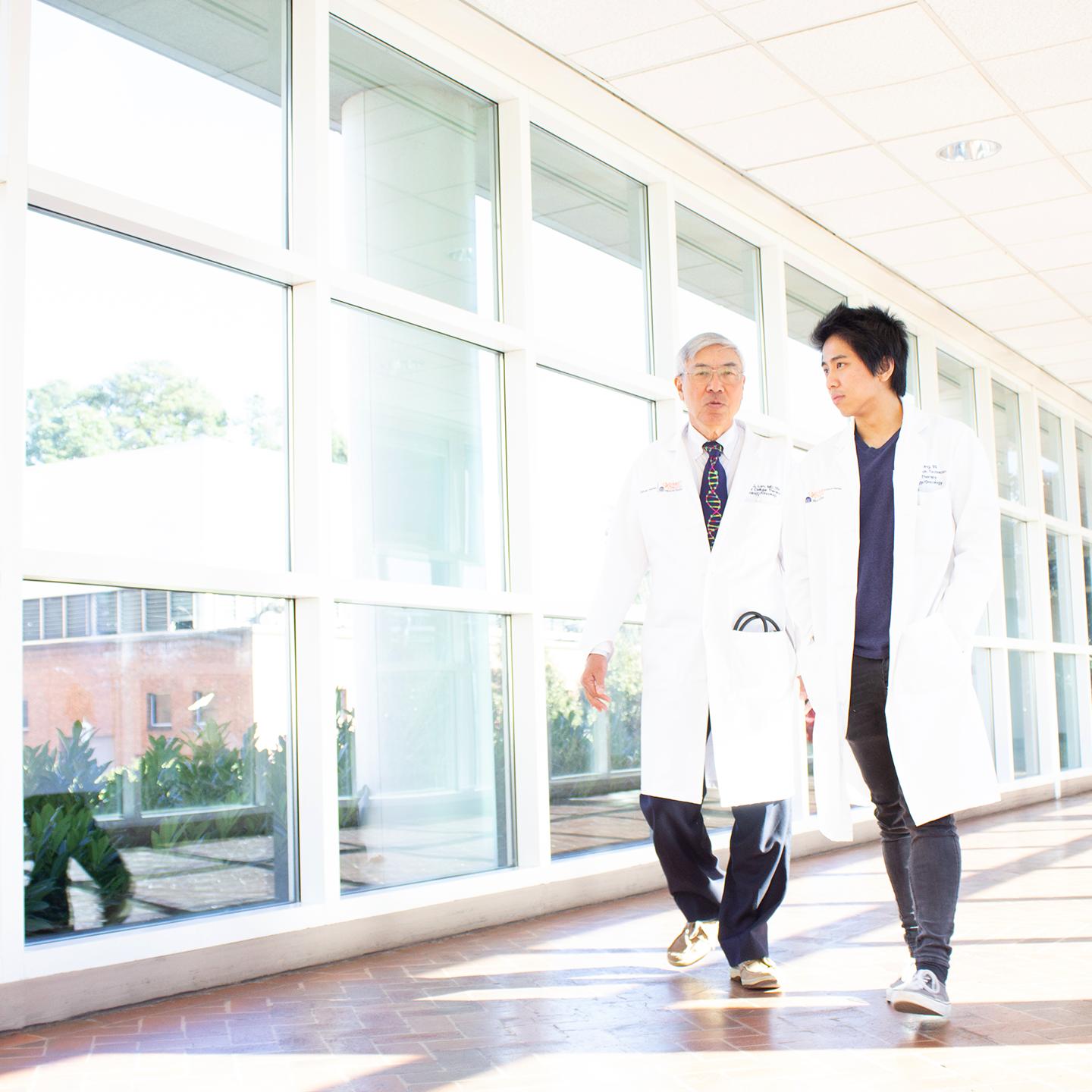 two men in white coats walking in a hallway