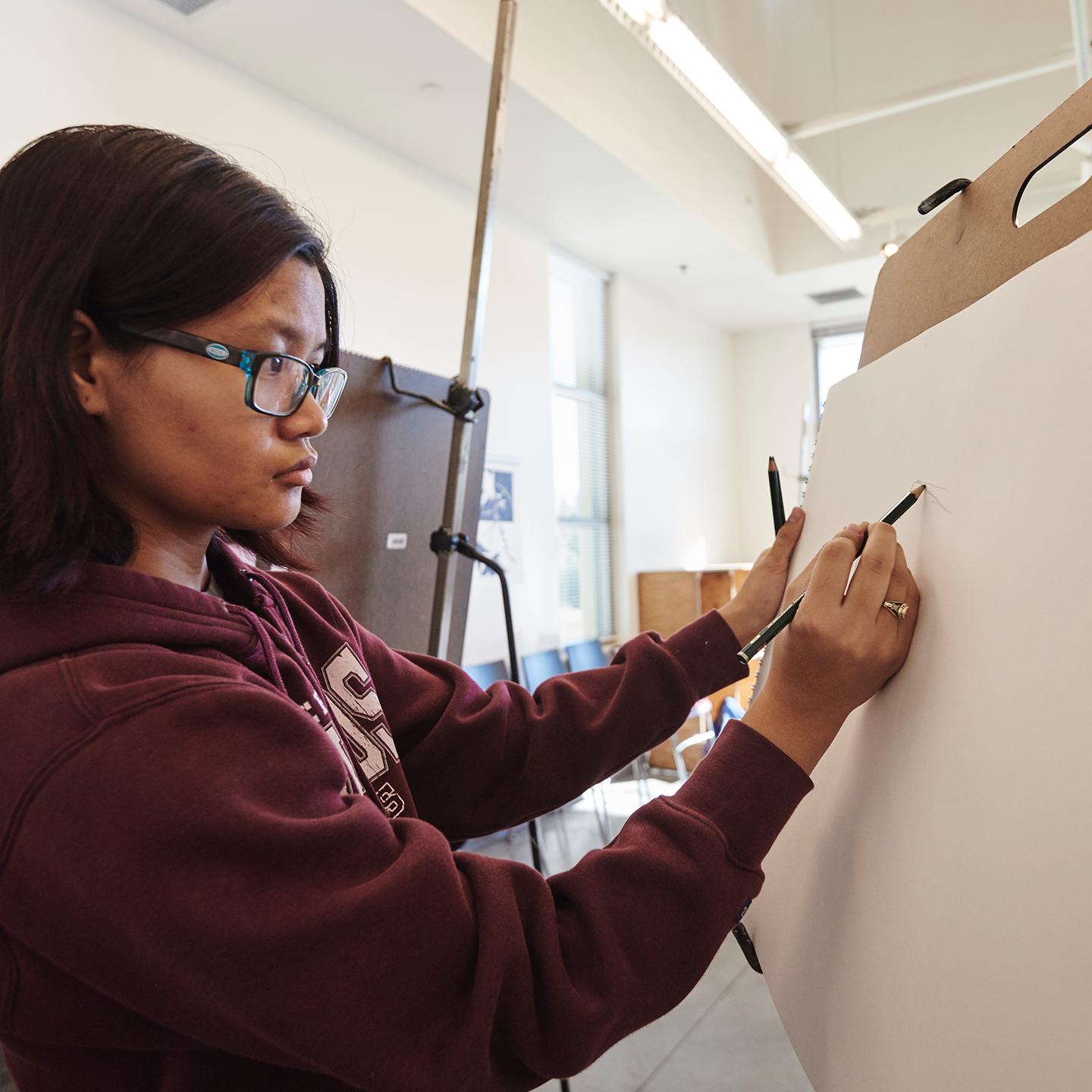 a woman drawing on a paper