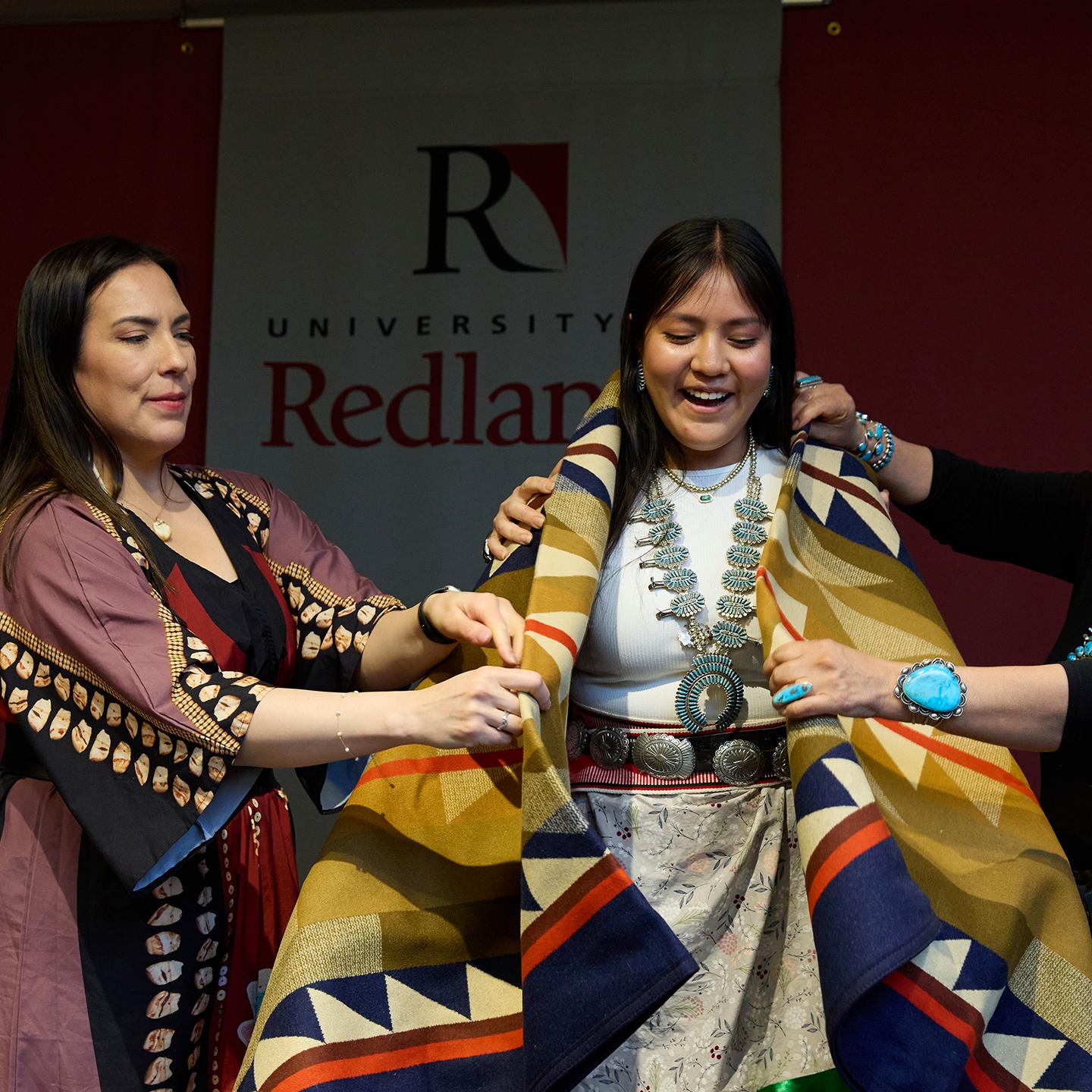 a group of women holding a blanket