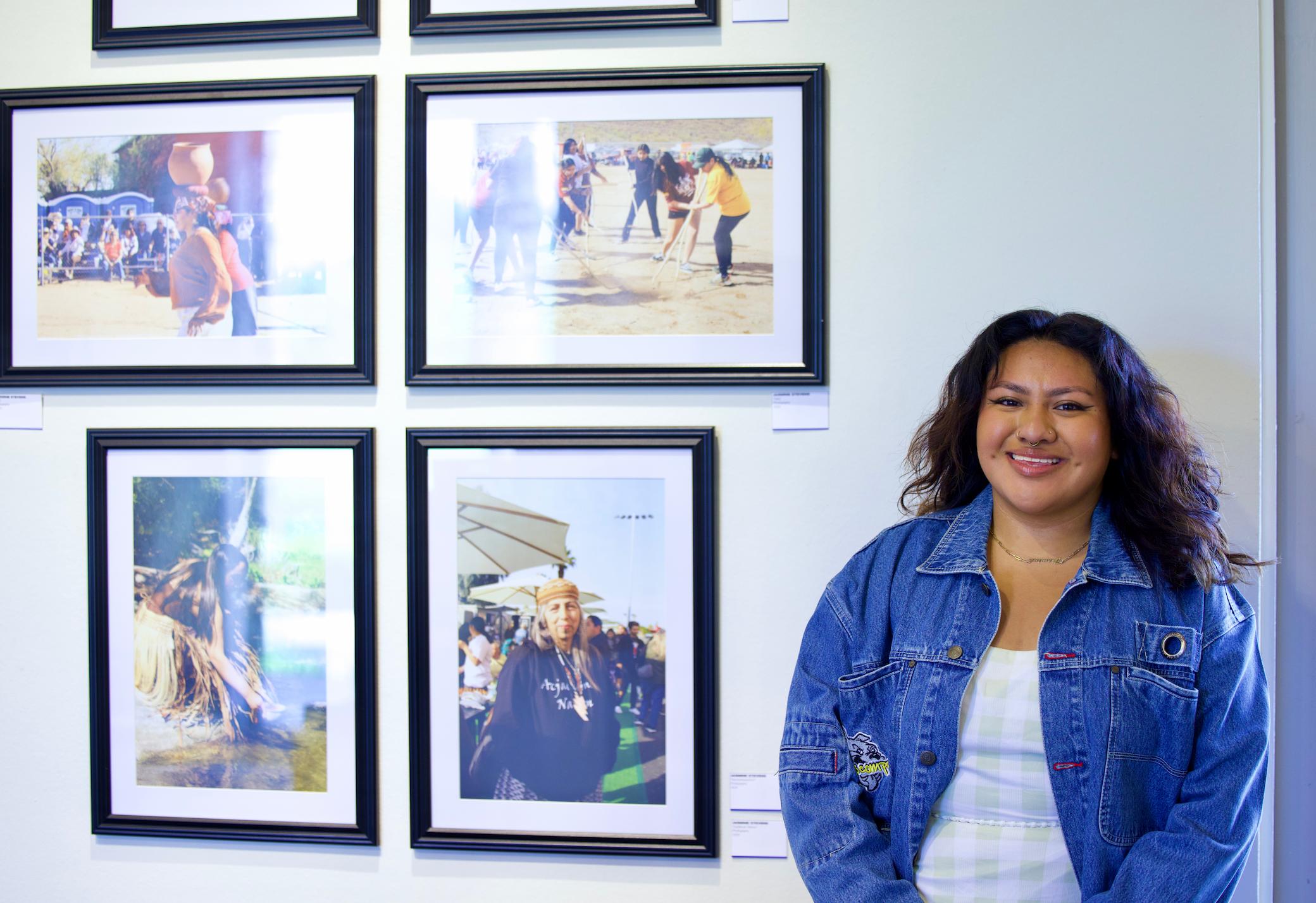 a woman standing next to a wall of pictures