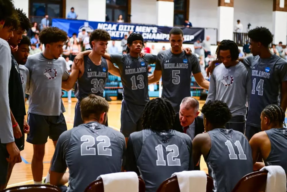 a group of men in a basketball team huddle