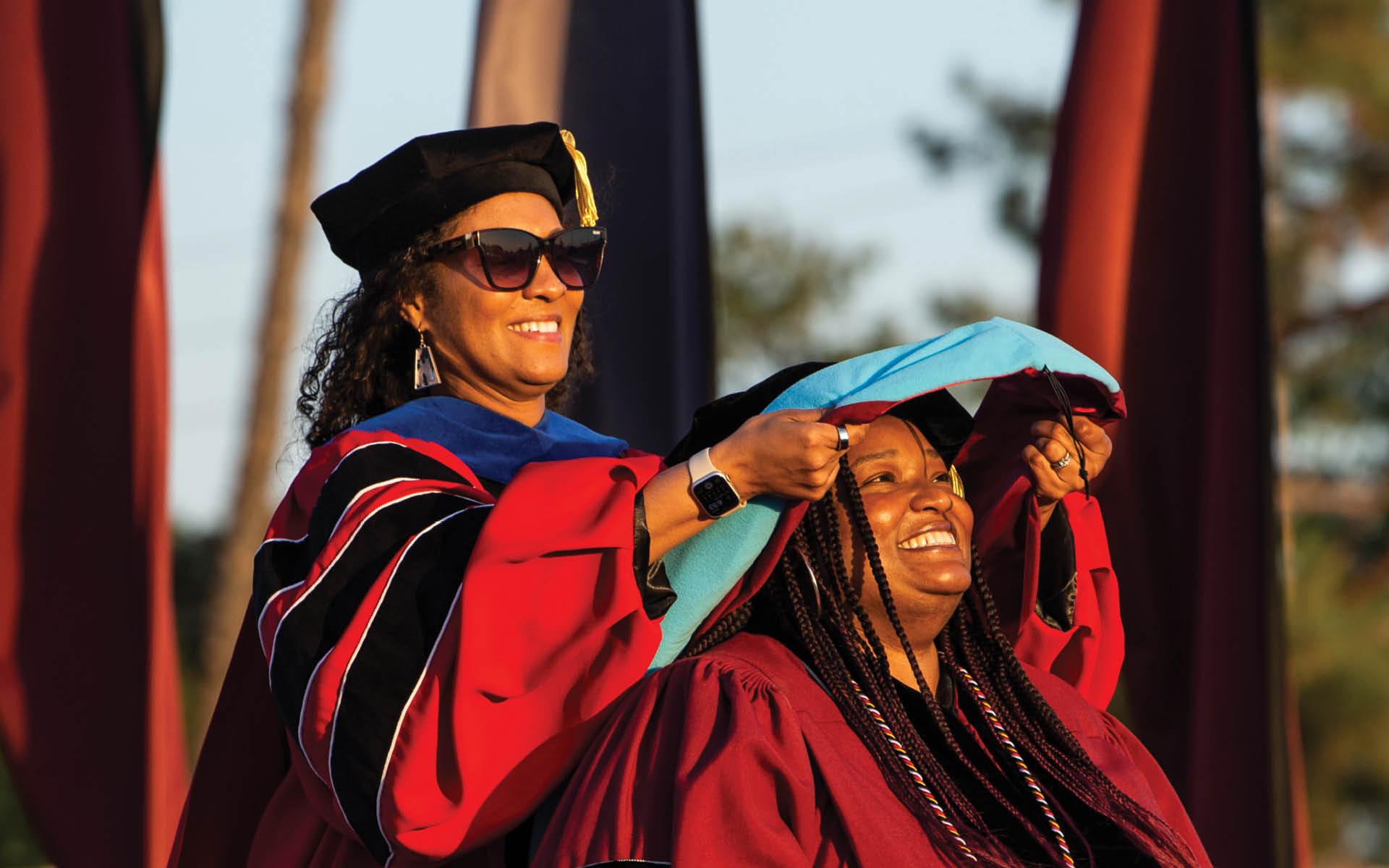 a woman putting on a cap on another woman