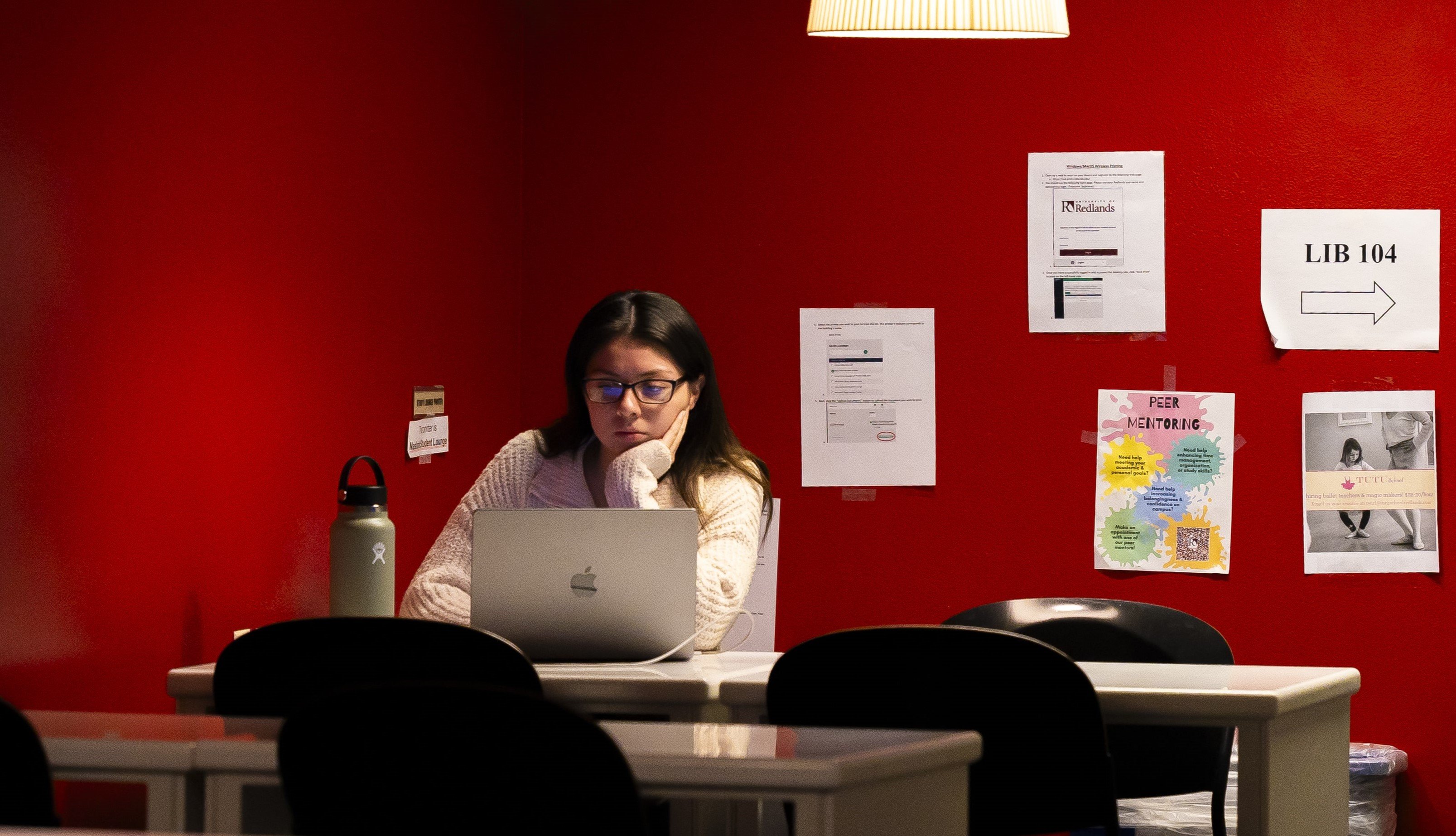 a woman sitting at a table with a laptop