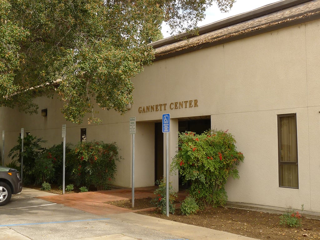 a building with a sign and trees