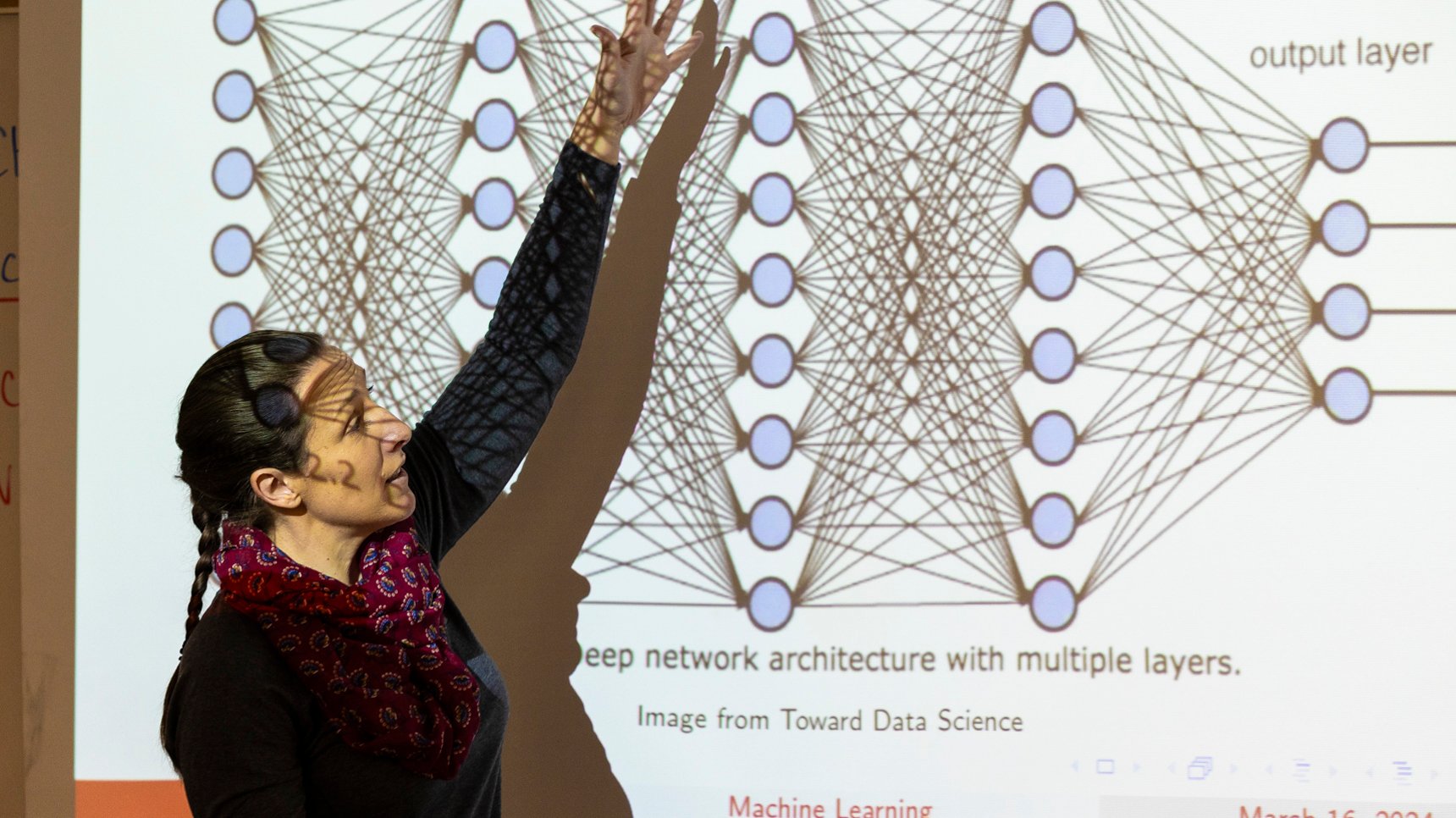 a woman standing in front of a projection screen