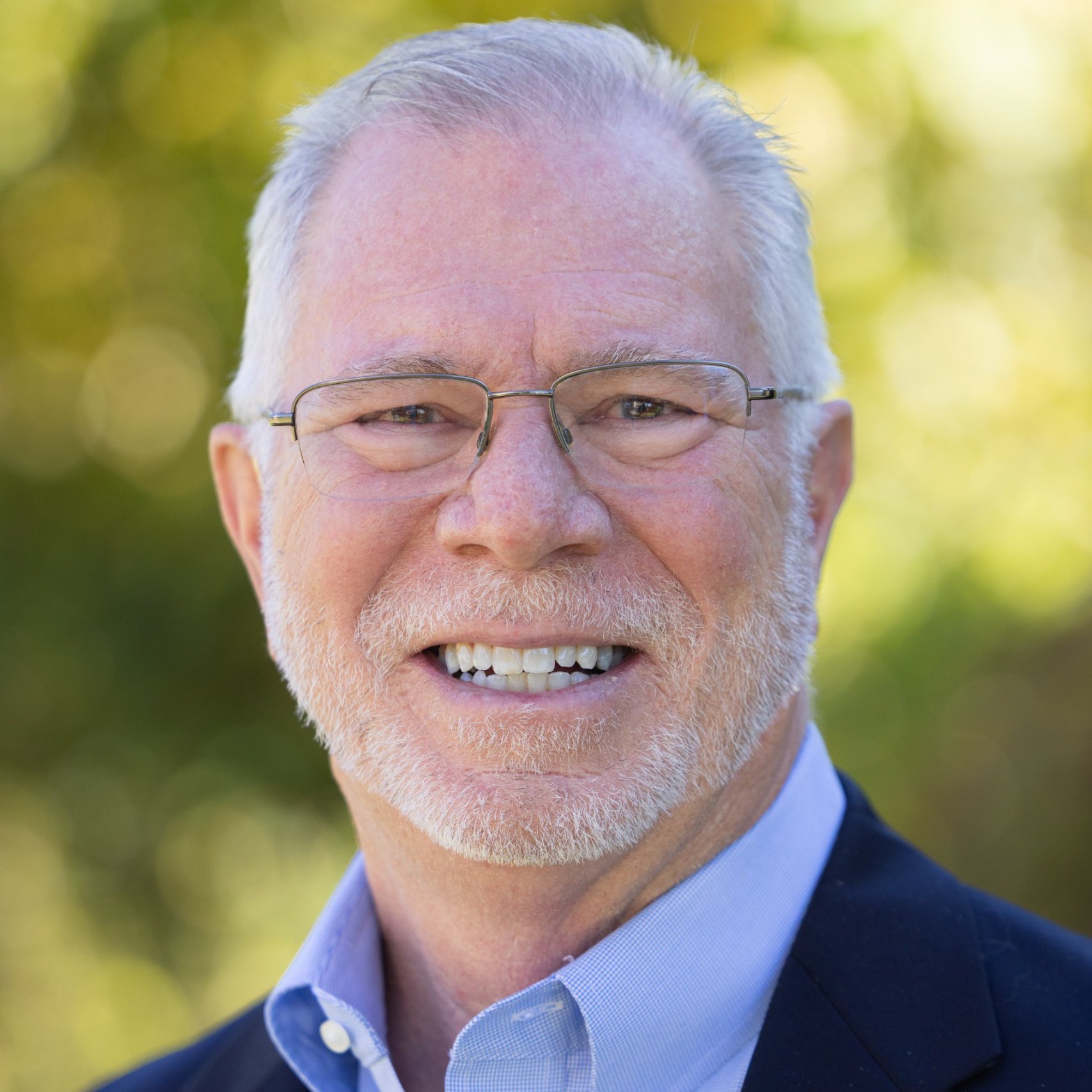 a man with glasses smiling