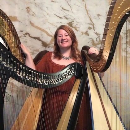 a person standing next to a group of harps