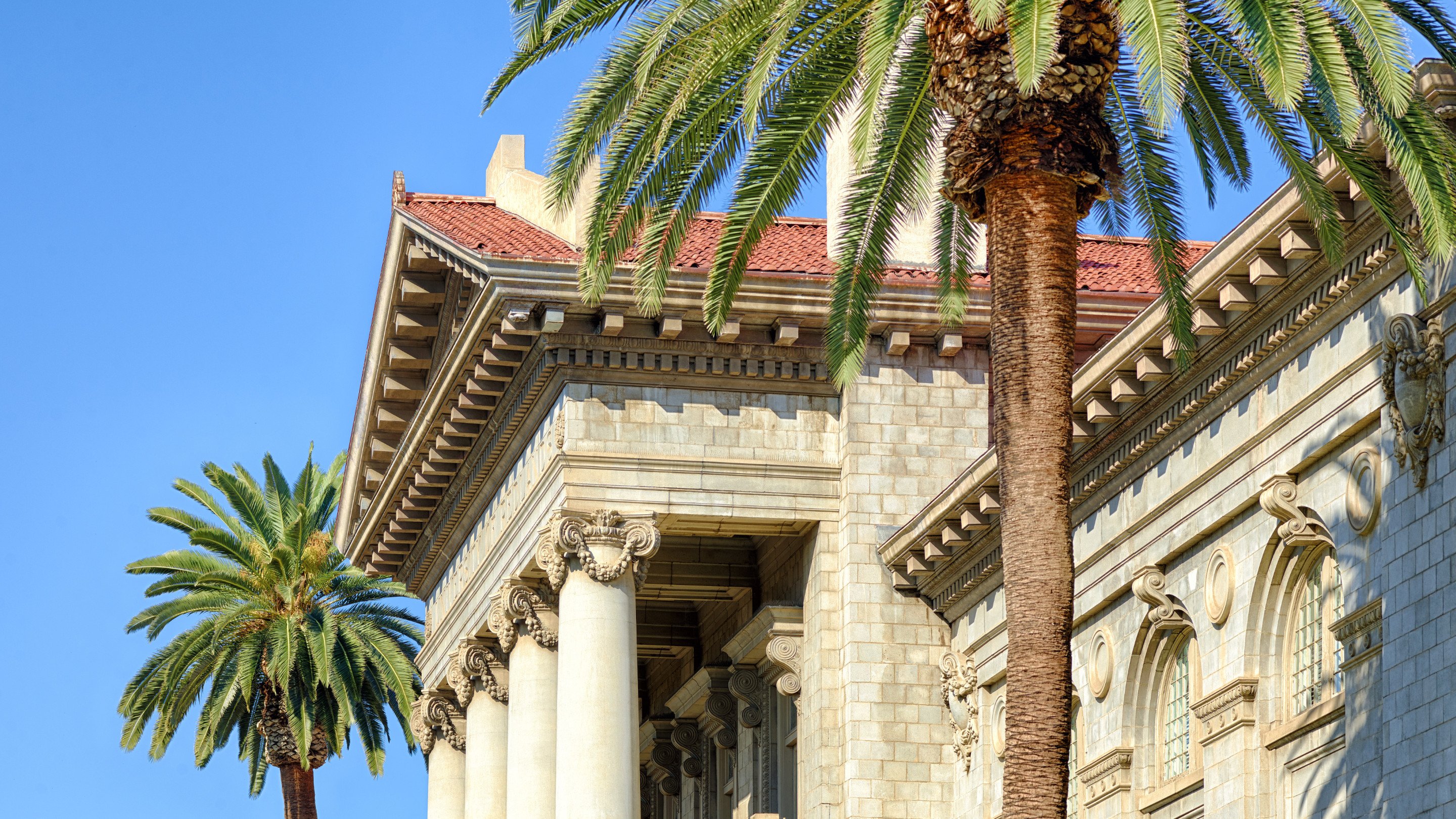 a building with columns and palm trees