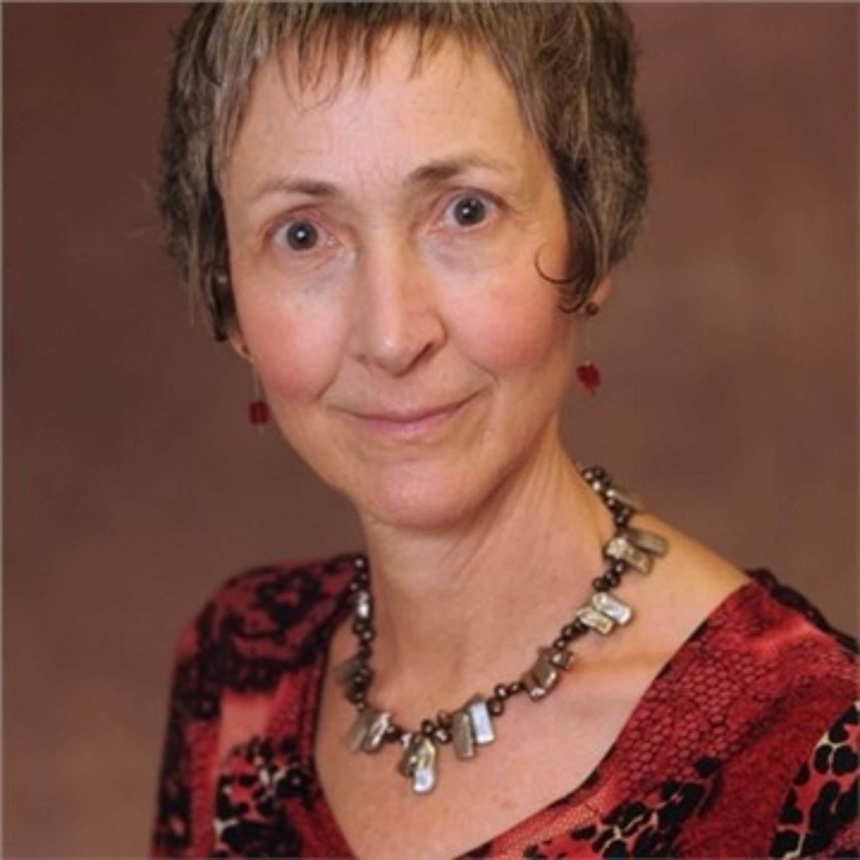 a woman with short hair wearing a necklace