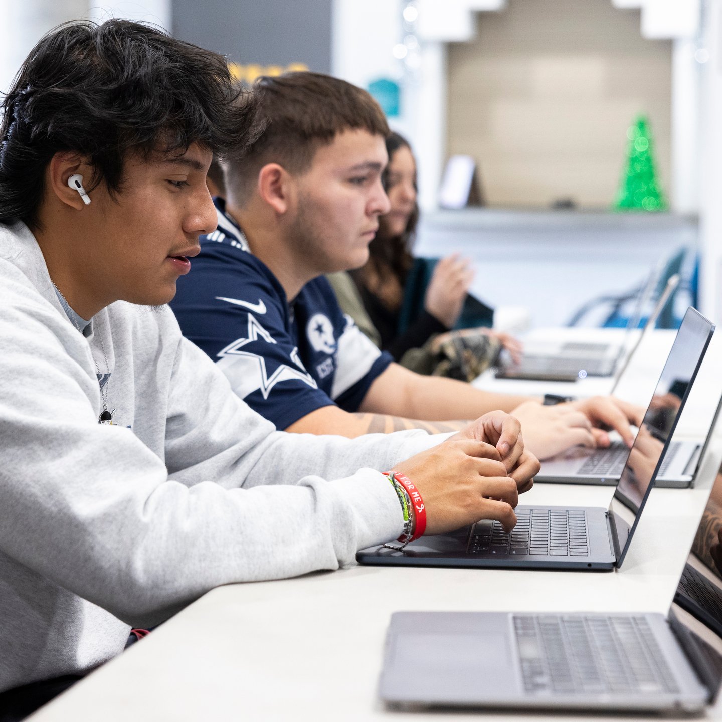 a group of people sitting at a table using laptops