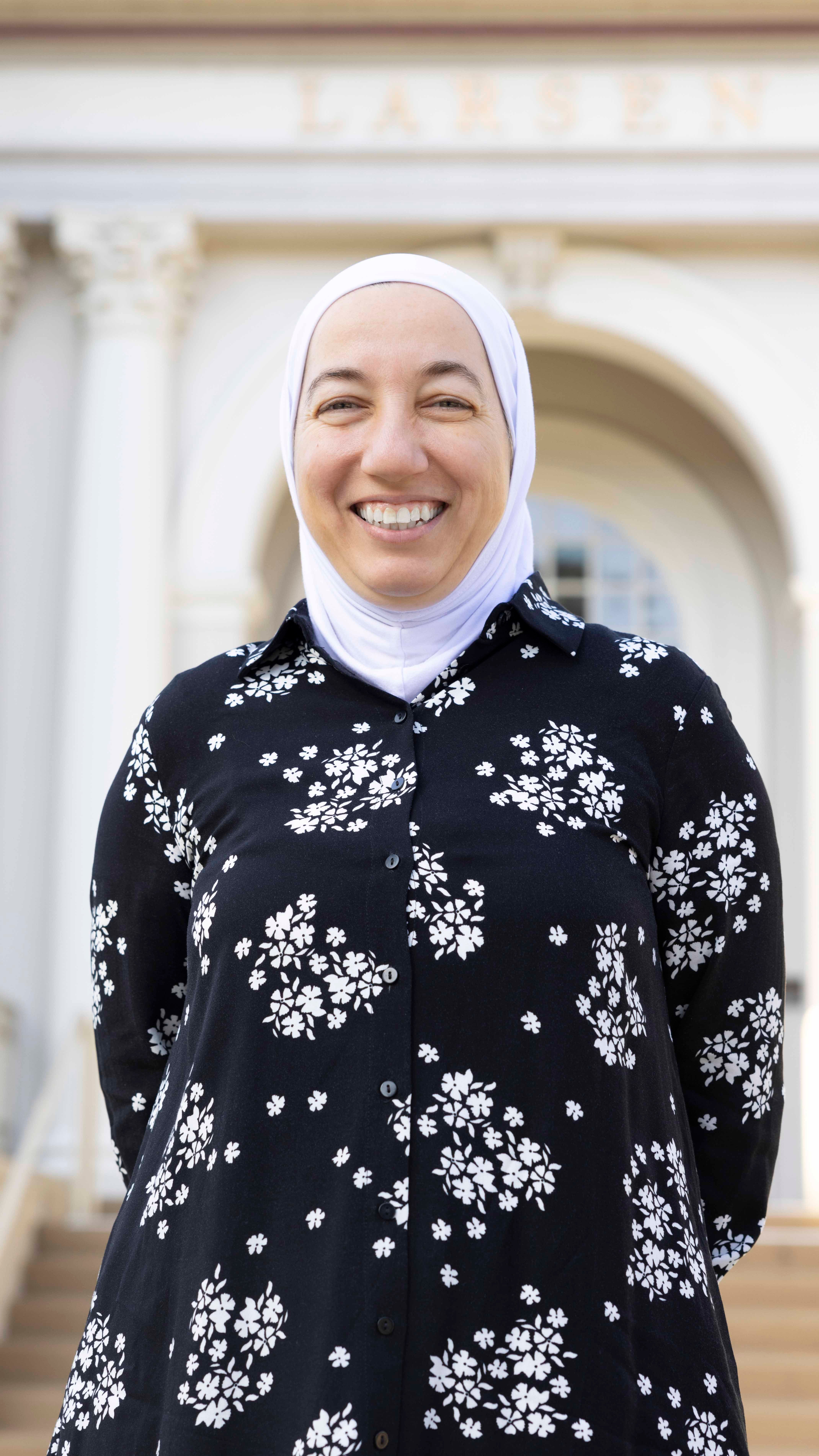 a woman wearing a head scarf smiling