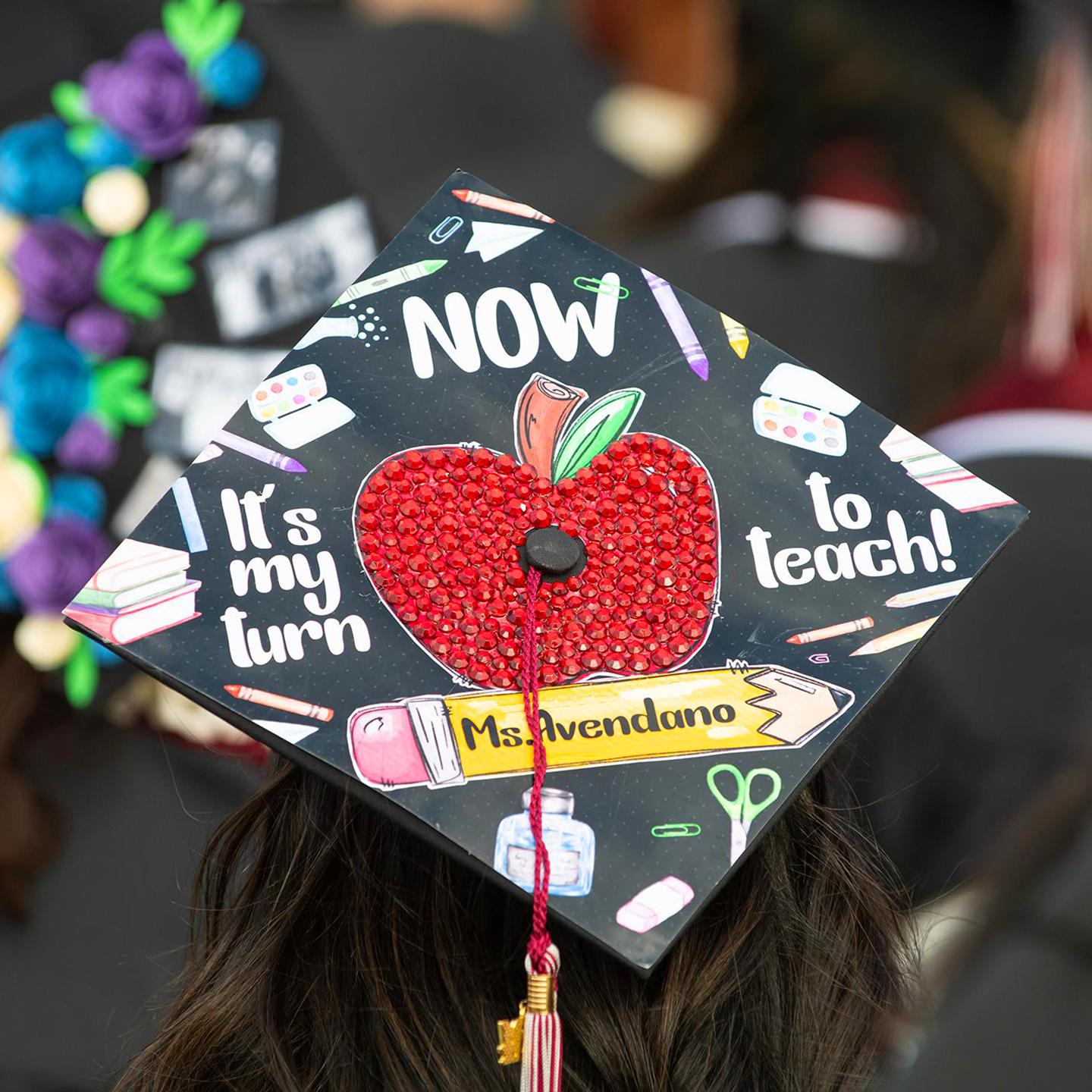 a graduation cap with a red apple on it