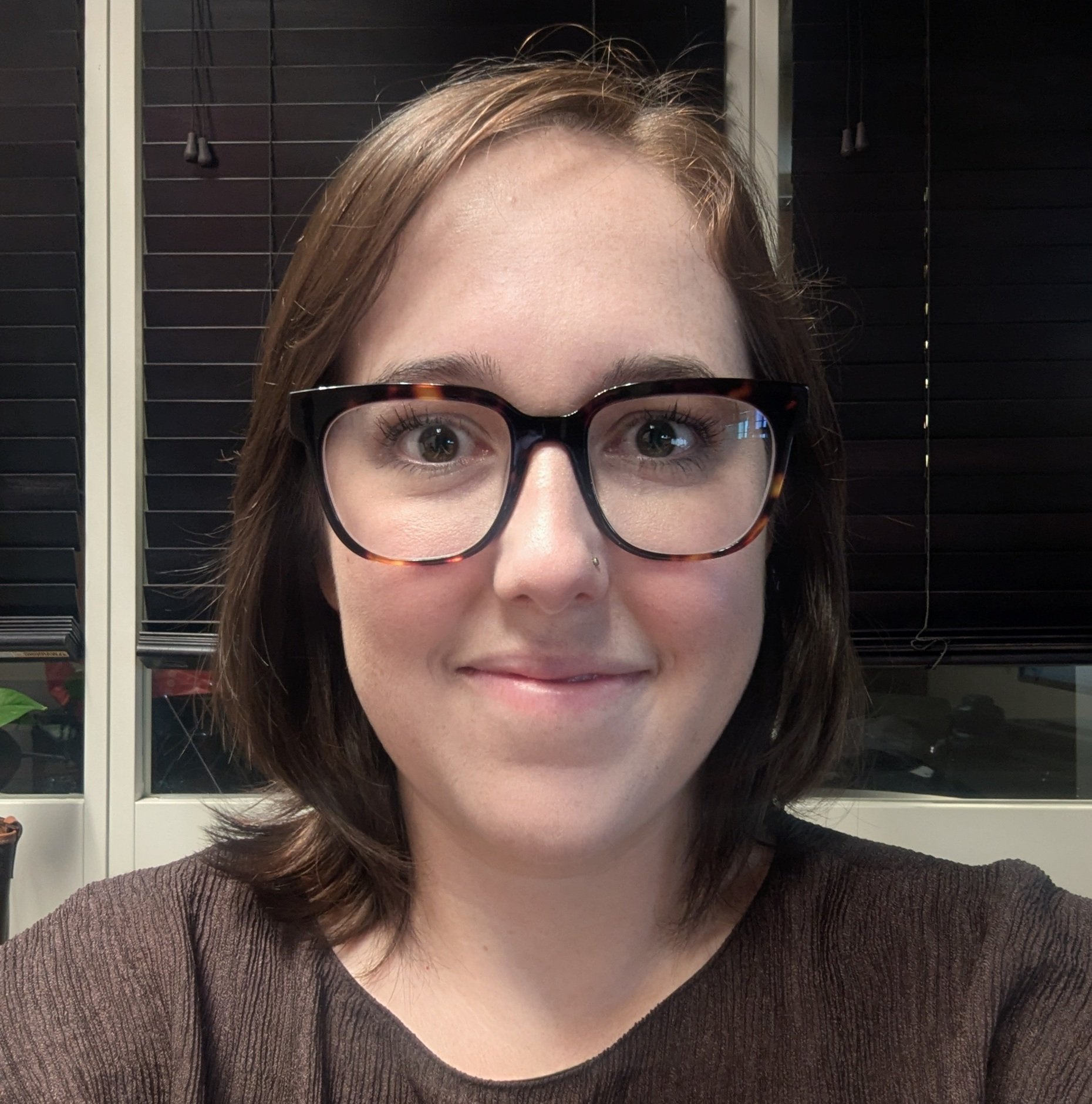 a woman wearing glasses smiling