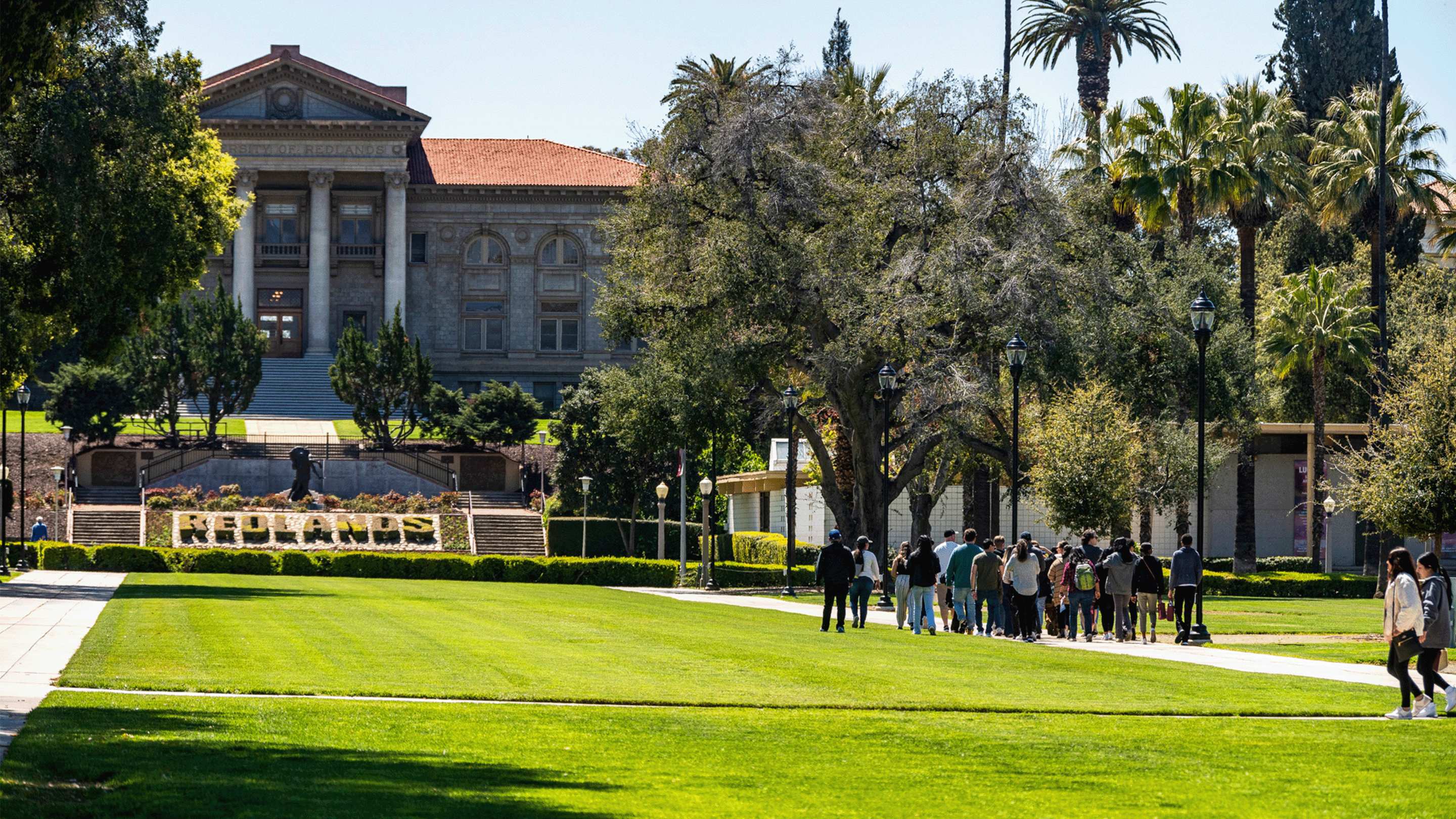 a group of people standing on a sidewalk in front of a building