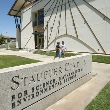 a man and woman walking in front of a building