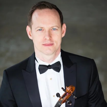 a person in a tuxedo holding a violin