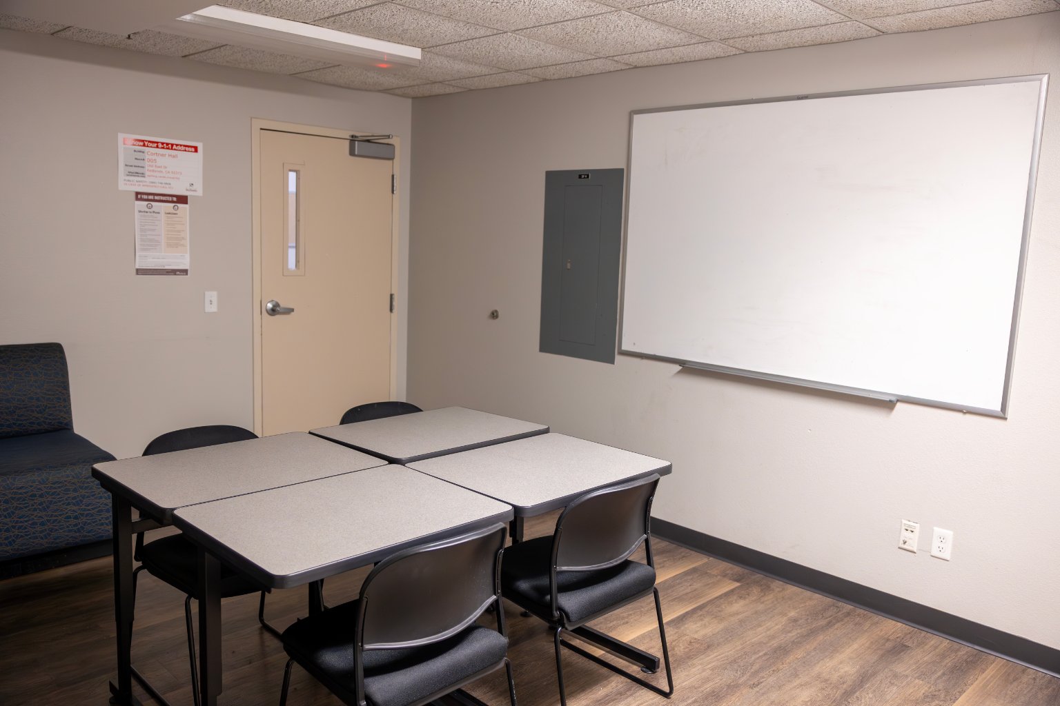 a room with a whiteboard and tables