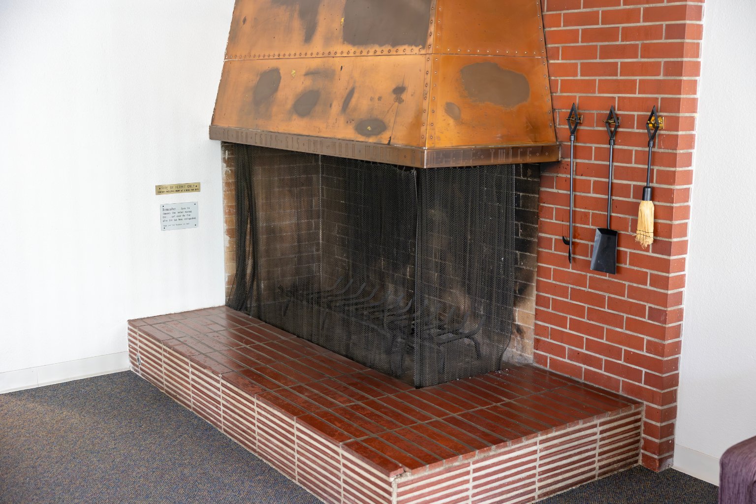 a fireplace with a brick wall and a metal chimney