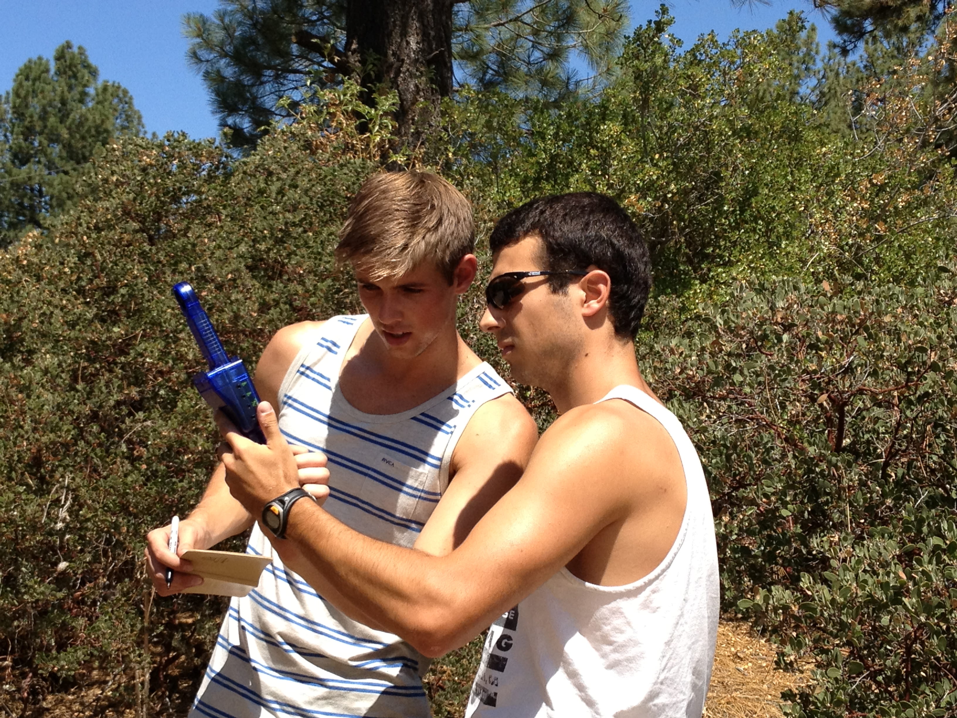 a man holding a blue toy gun next to another man