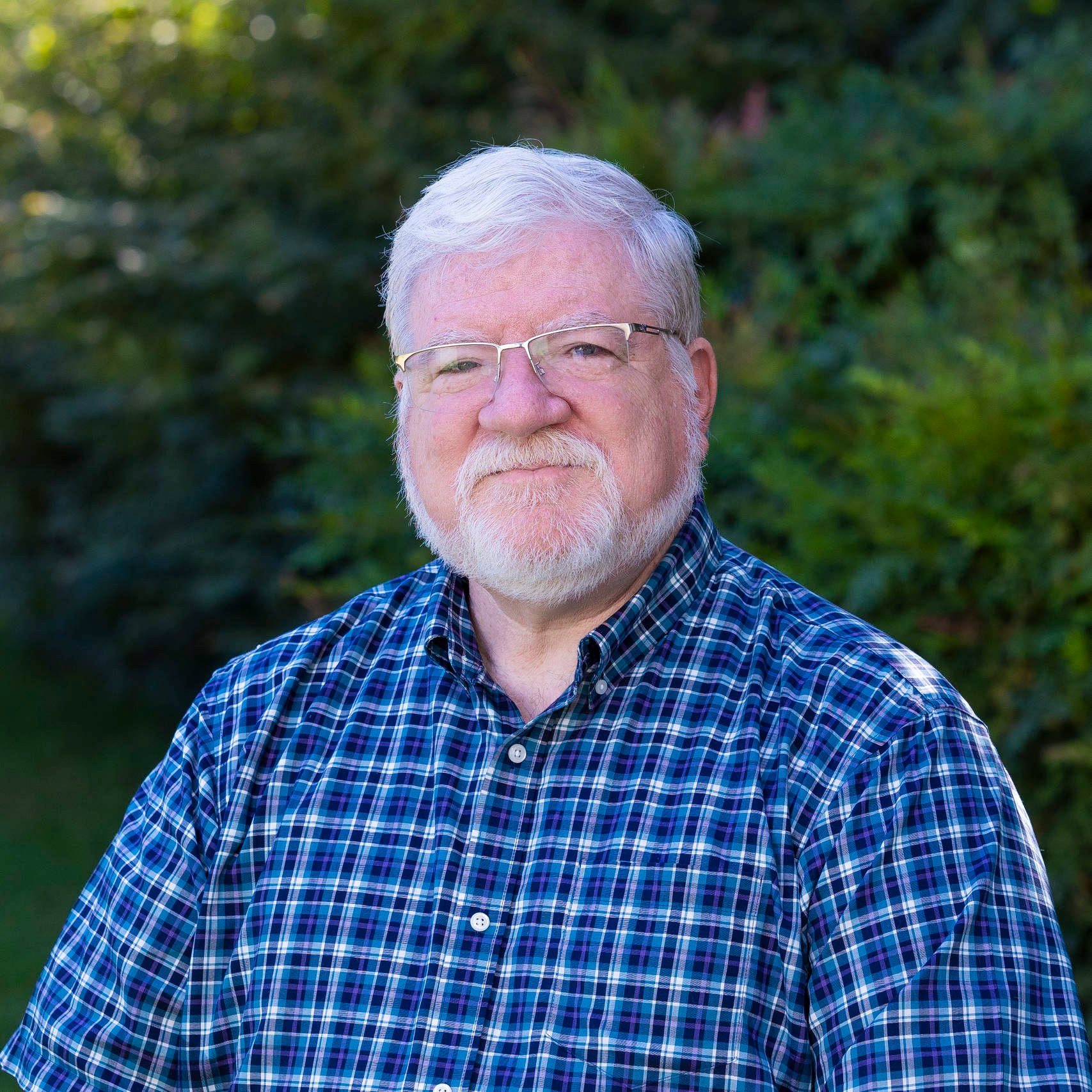 a man with white hair and beard wearing glasses