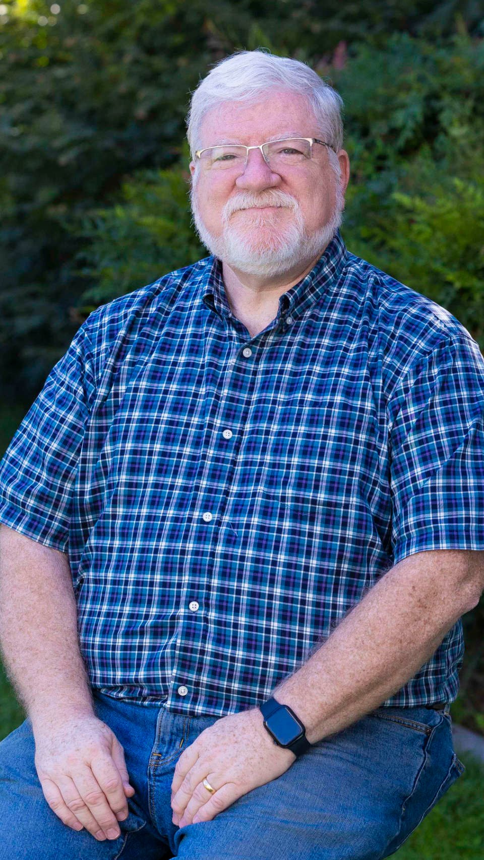 a man with a beard and mustache wearing a blue plaid shirt