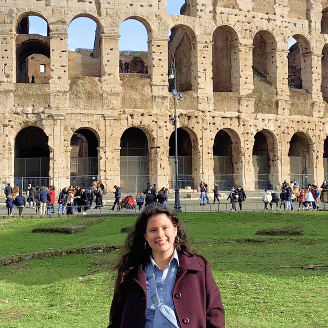 a woman standing in front of an ancient building