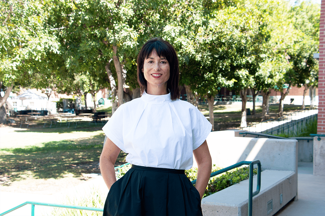 a woman standing in front of trees