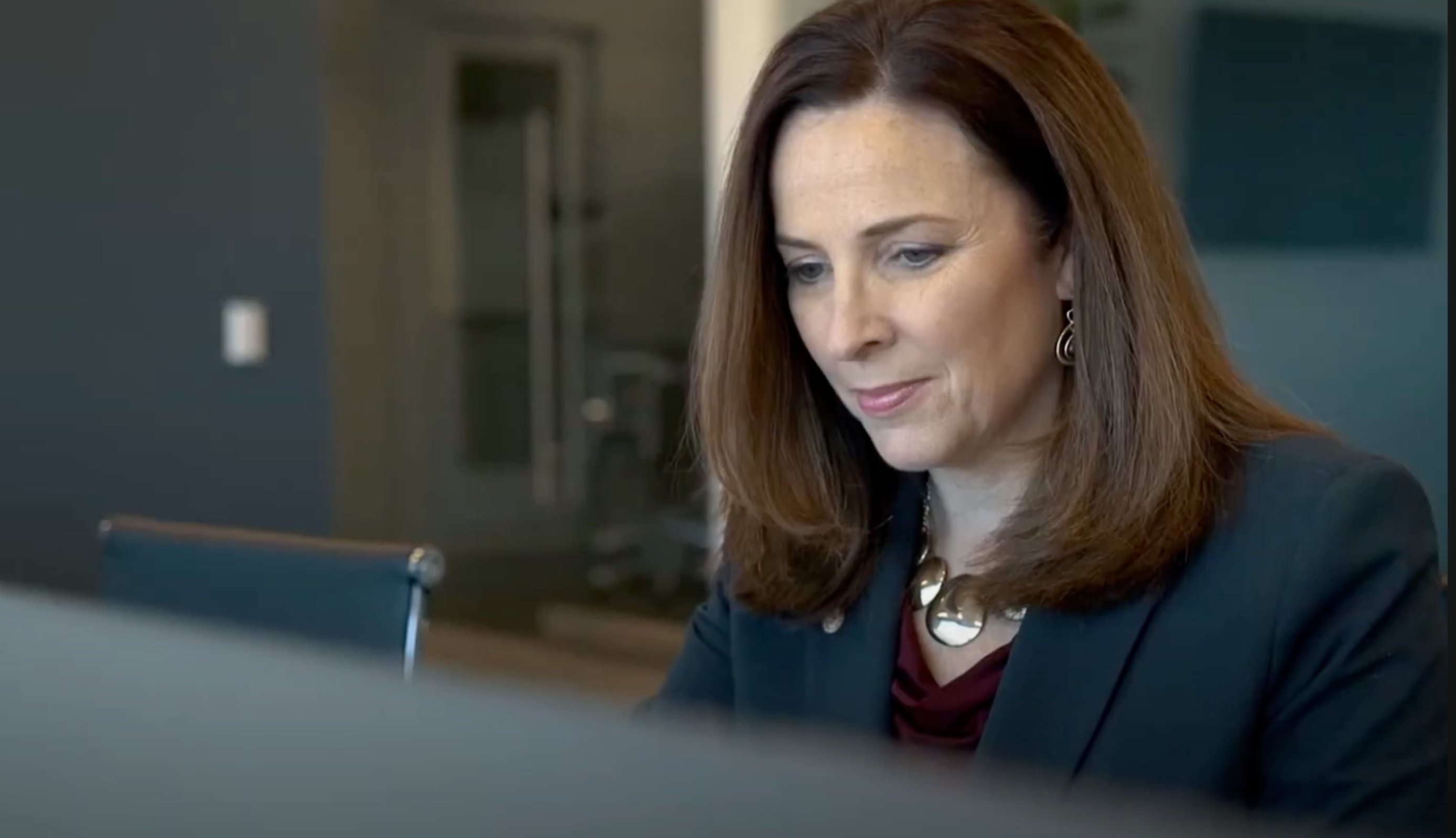 a woman looking down at a computer screen