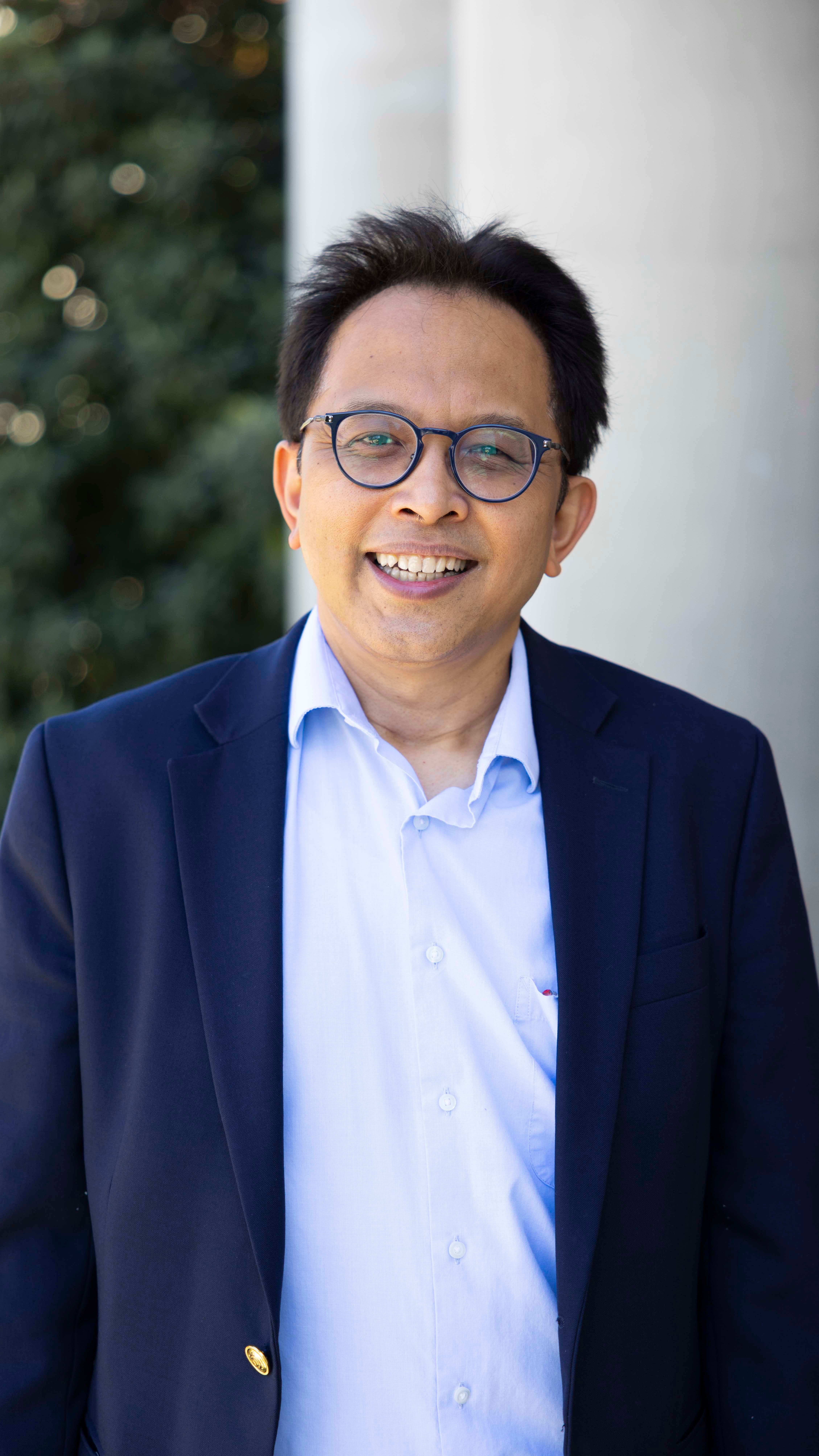 a man wearing glasses and a suit jacket