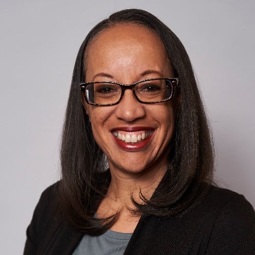 a woman wearing glasses smiling