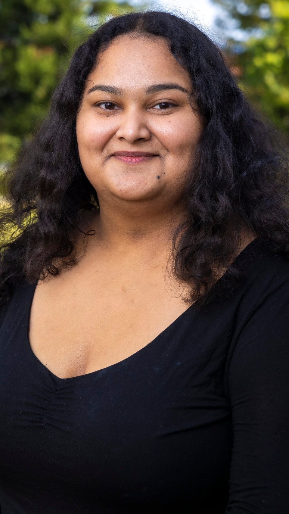 a woman with long curly hair wearing a black shirt