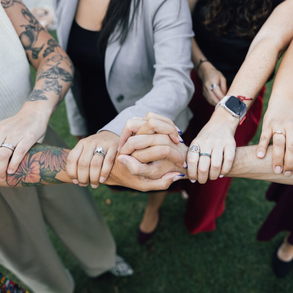 a group of people holding hands together
