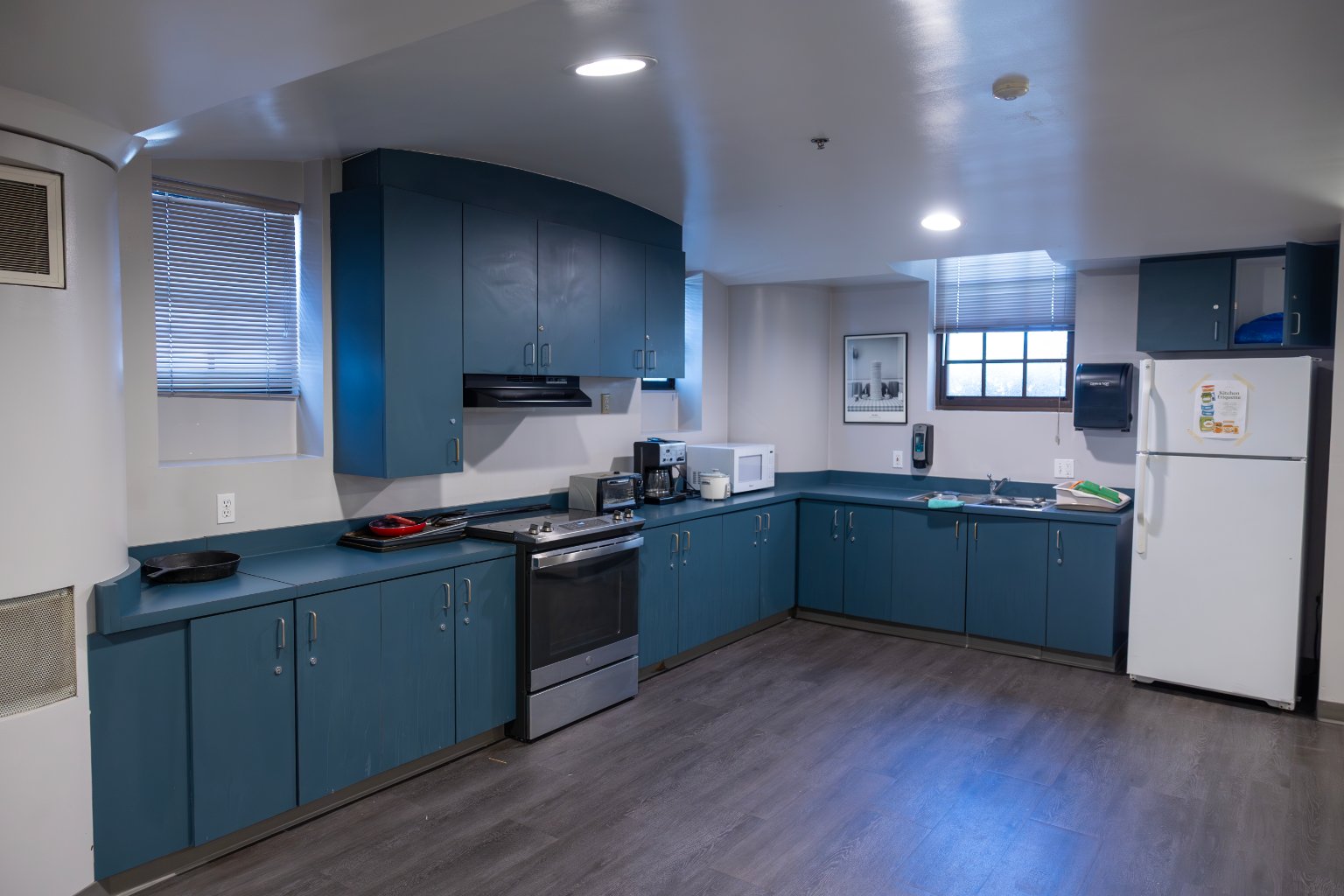 a kitchen with blue cabinets and a wood floor