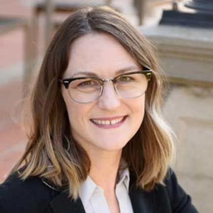 a woman wearing glasses and a suit