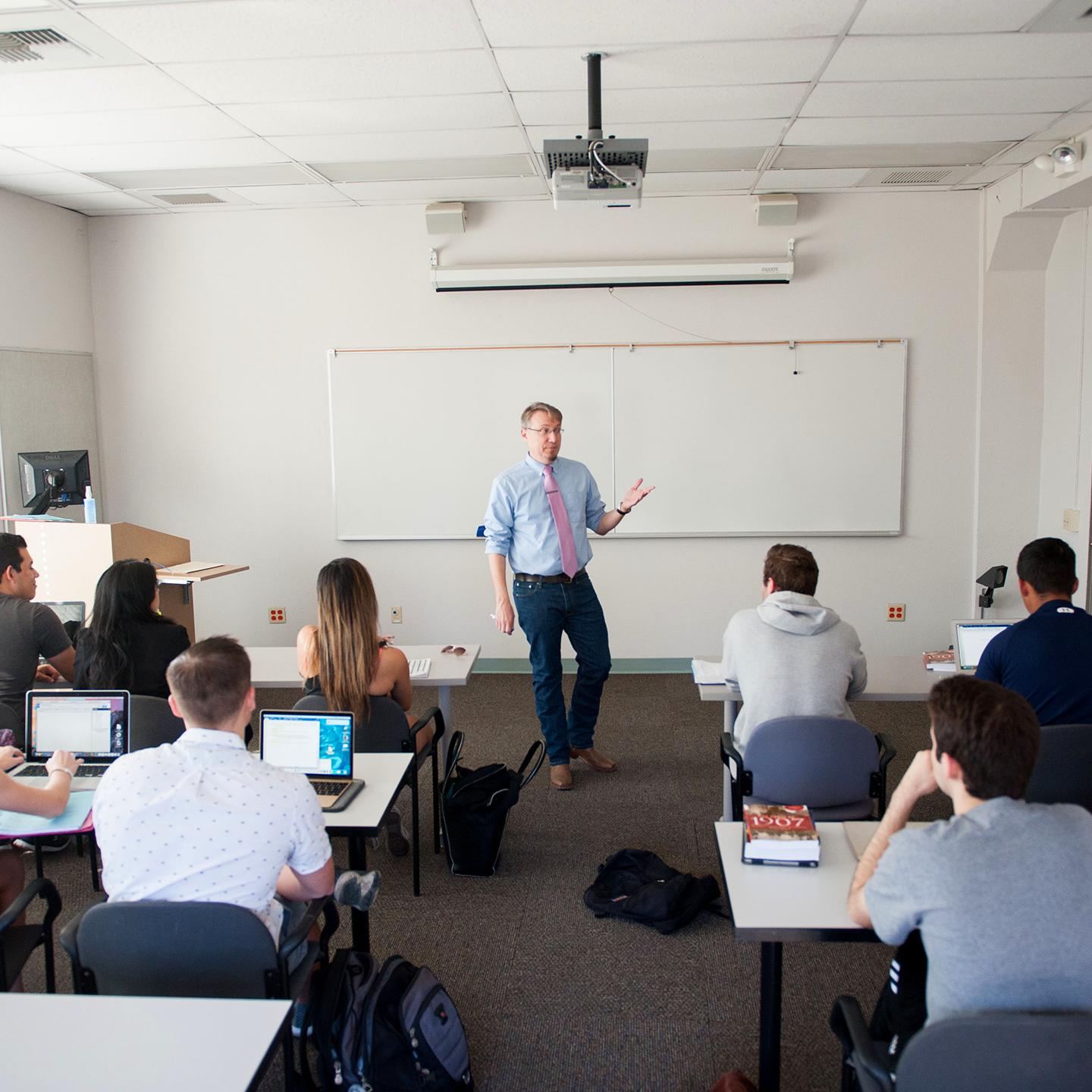 a man standing in front of a classroom with a group of people